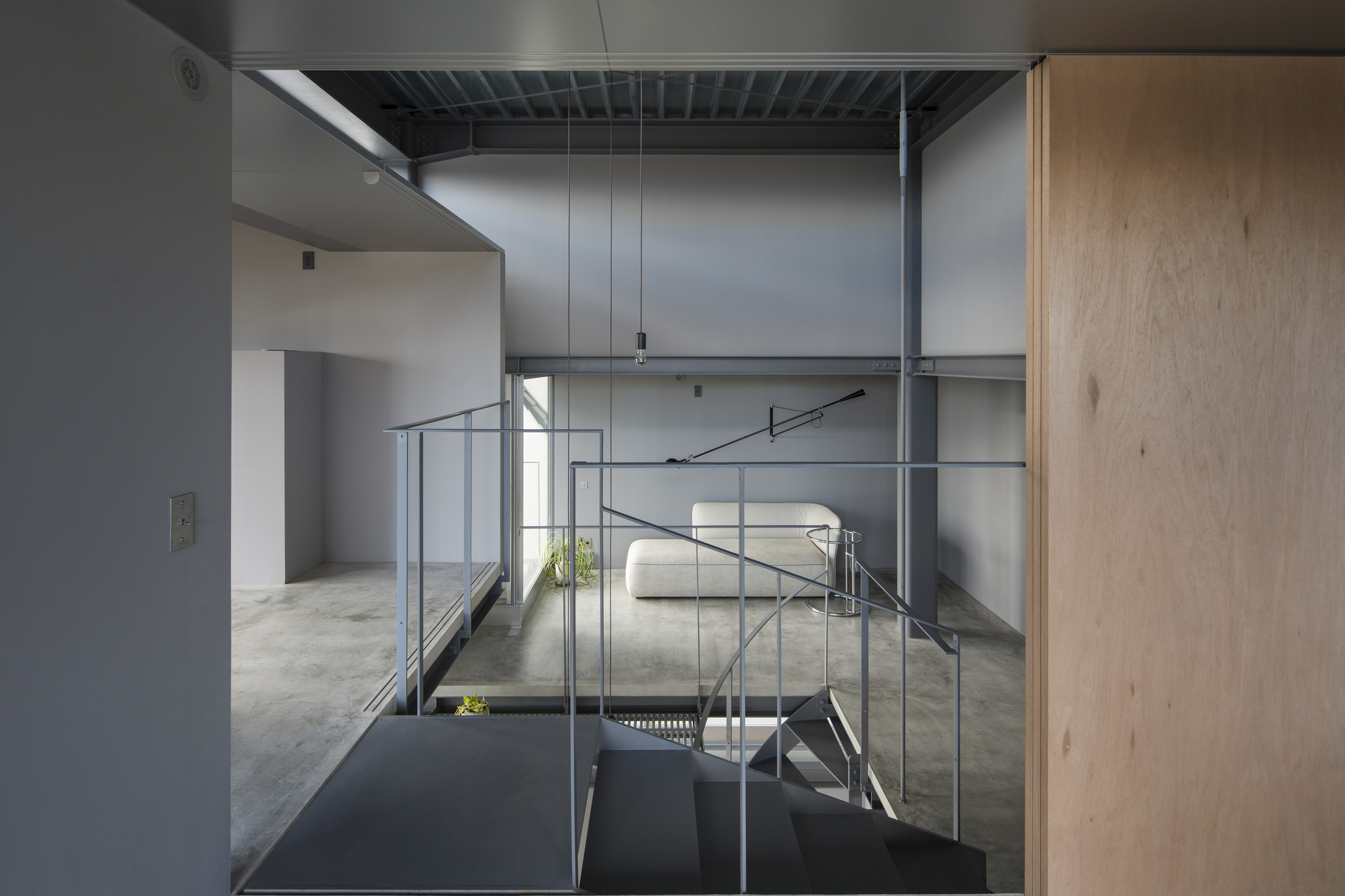 View across the upper floor with steel handrails and exposed ceiling joists in diffused daylight