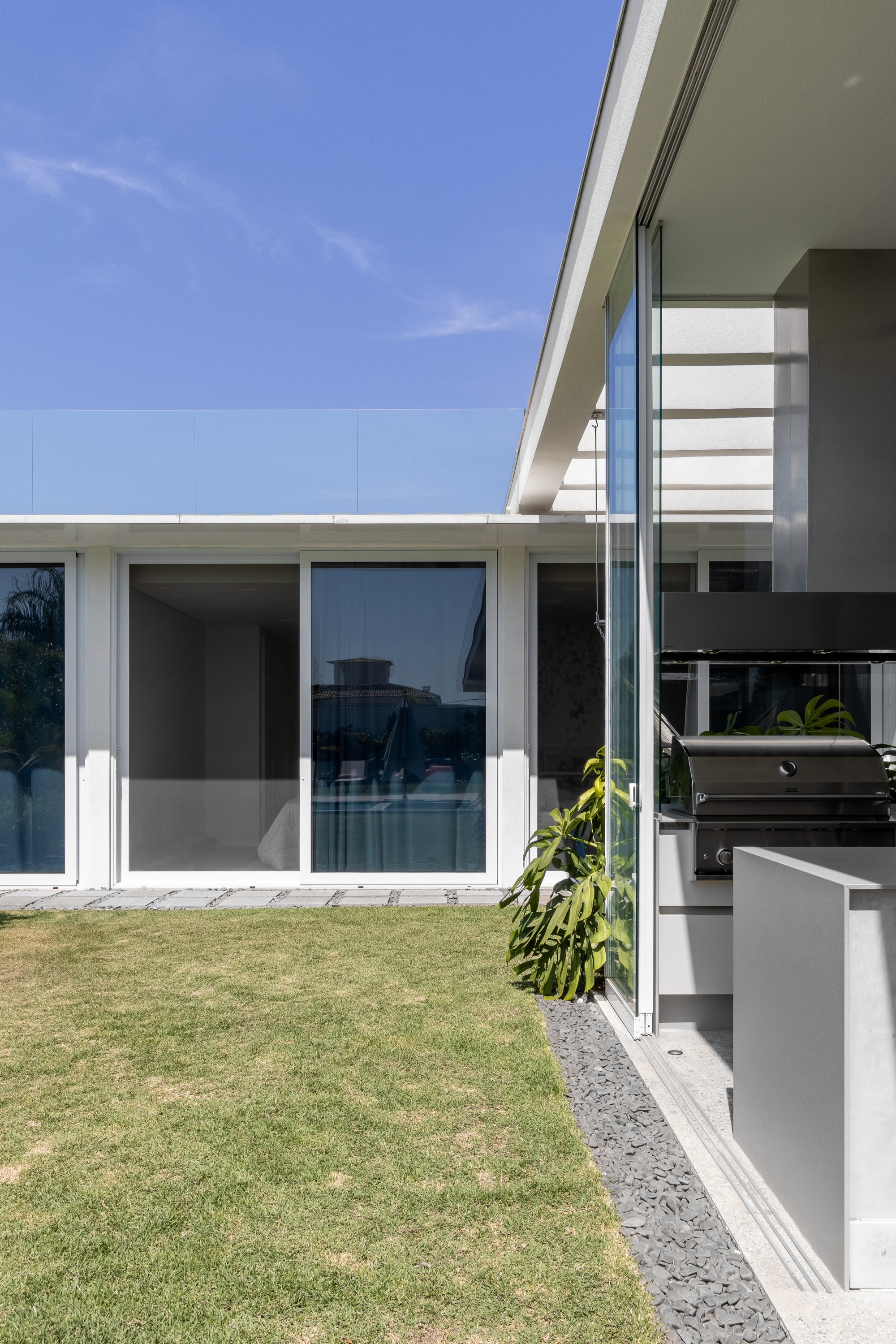 Exterior view of the glass sliding doors opening to the lawn from the covered terrace