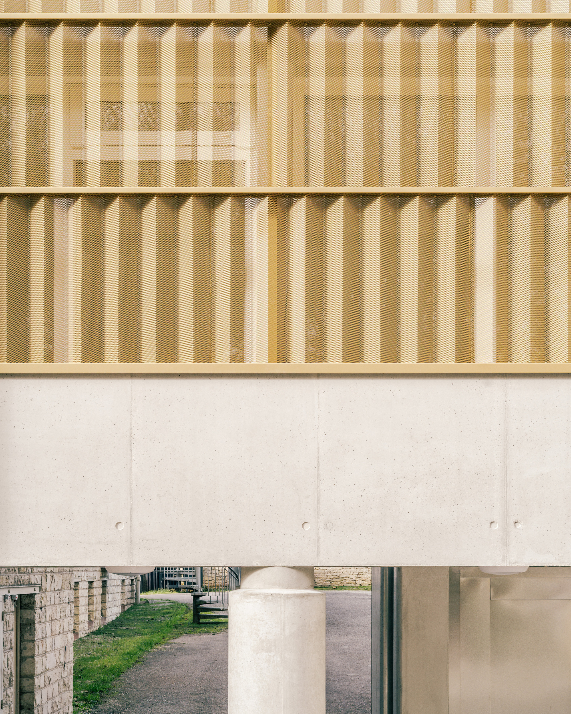 Timber batten screen above a concrete beam with a glimpse of courtyard through the opening below