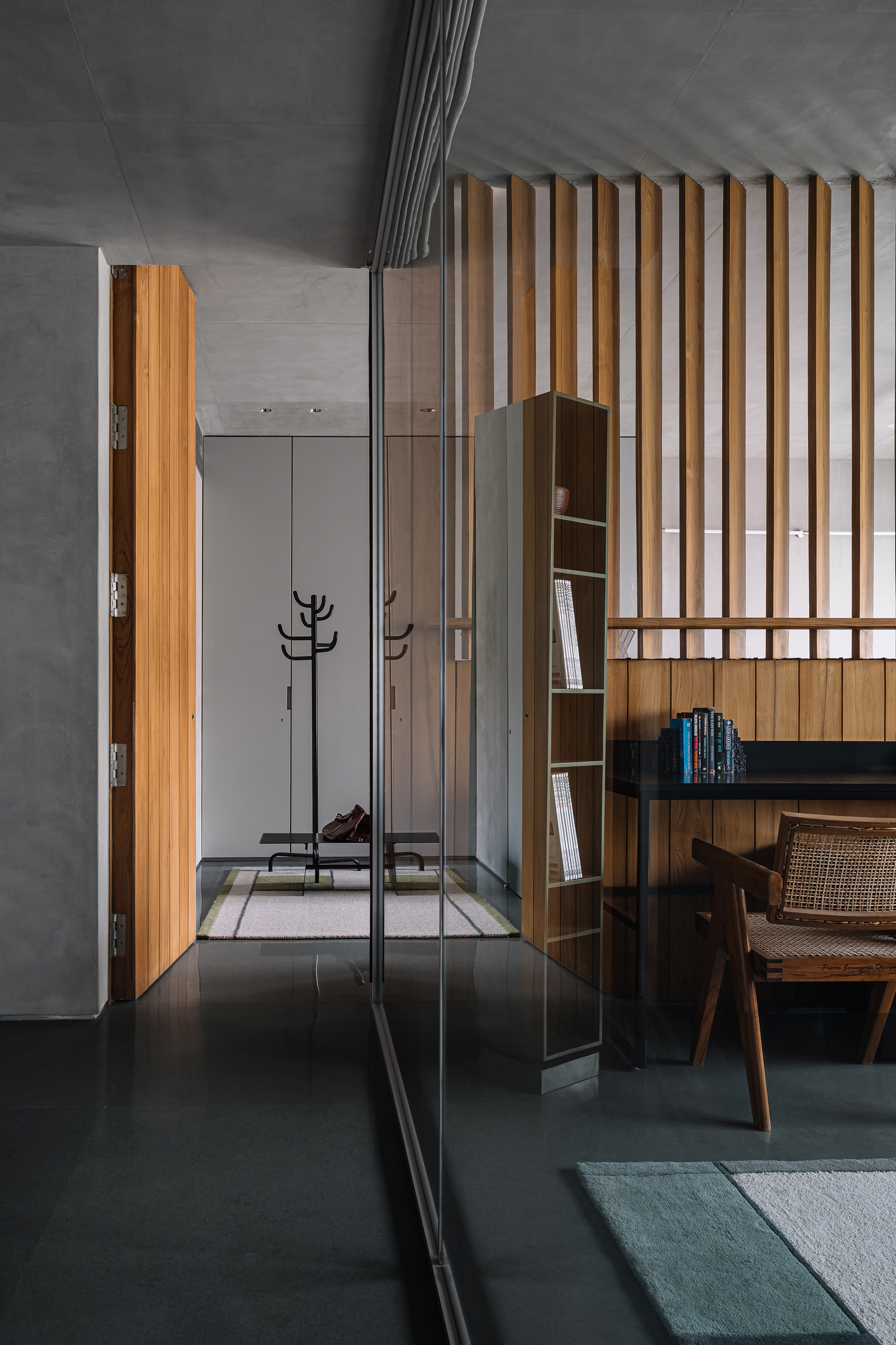 Timber slat partition reflected in full-height mirror beside built-in storage closet