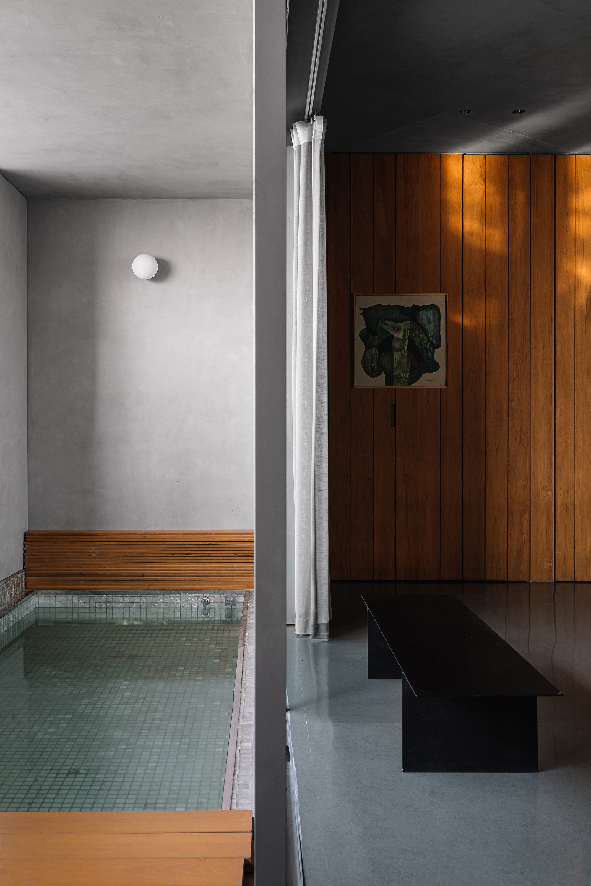 View through doorway revealing sunken pool with timber edge bench and tiled base
