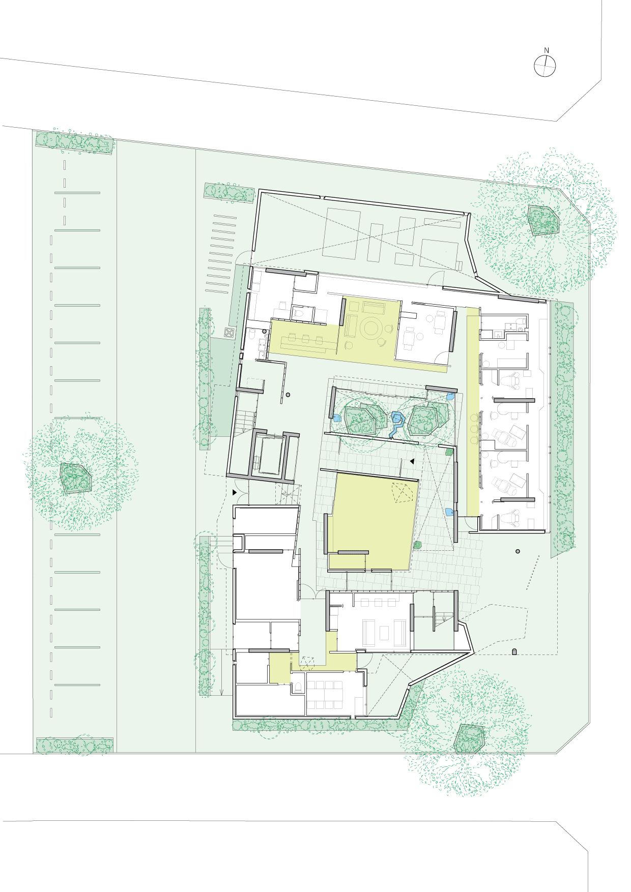 Site plan drawing depicting the building layout with courtyards and surrounding landscape including trees