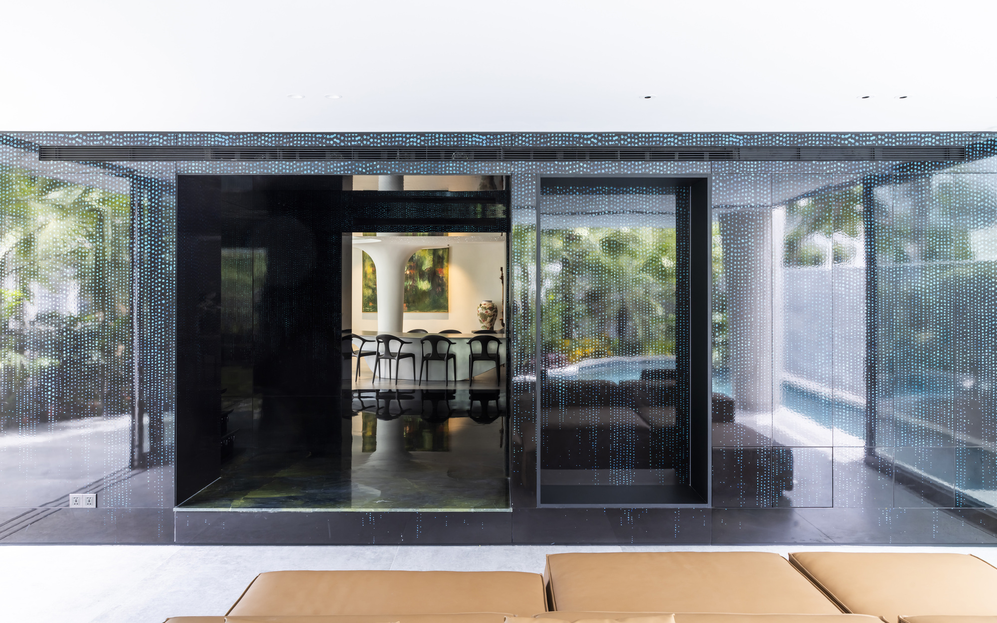 Covered terrace with perforated metal screens framing views to the dining area and pool beyond