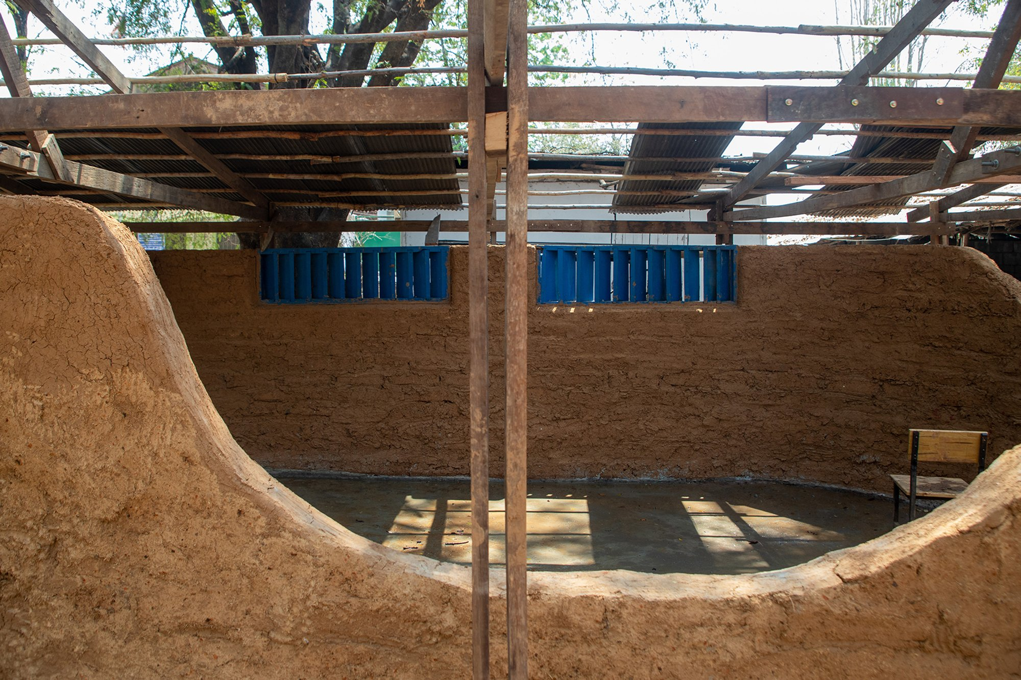  Interior view showing curved earthen walls shaping a flexible and open learning space.