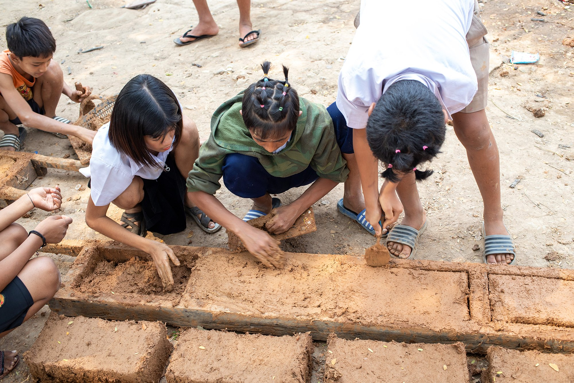  Students actively participate in making mud blocks using simple, local techniques.