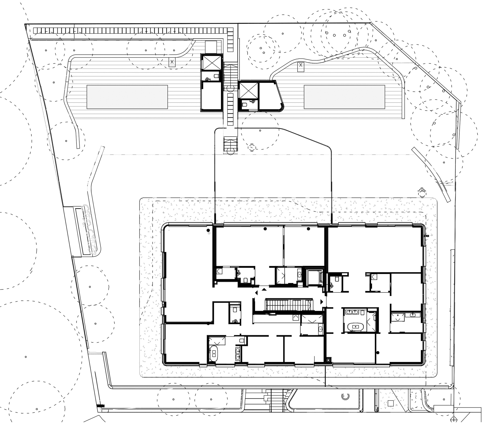 Site plan drawing showing two rectangular buildings with a connecting core and surrounding landscape with trees