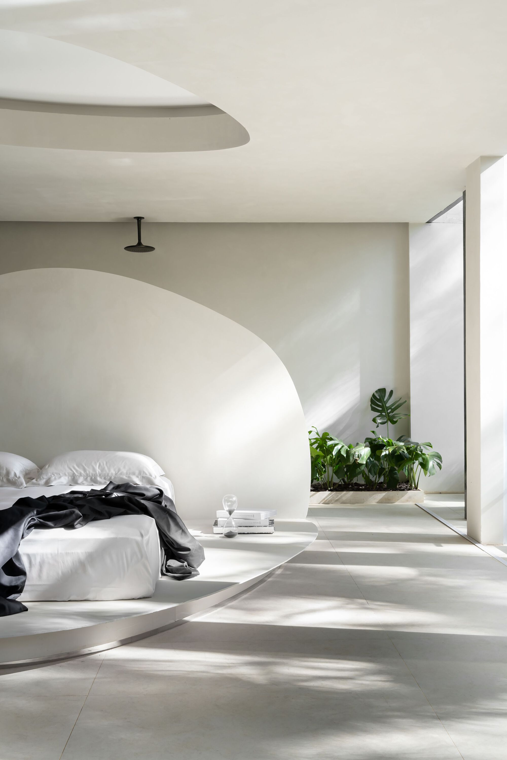Low angle of curved bed platform with streaming morning light across pale floor tiles