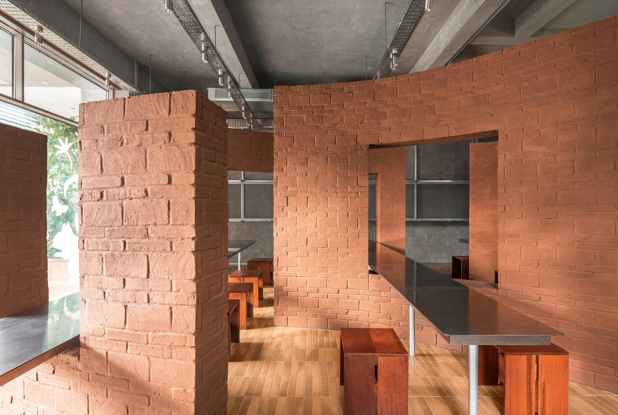 Terracotta brick partition walls with stepped seating and framed views through multiple openings