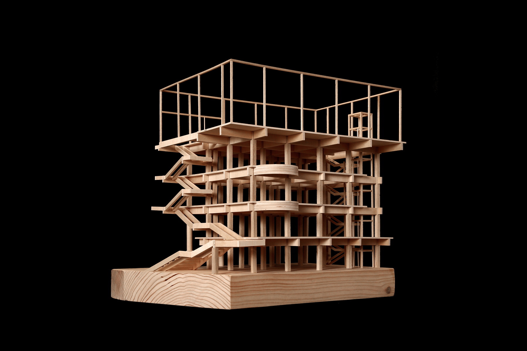 Physical model of timber post-and-beam structure with cantilevered floors photographed against black background