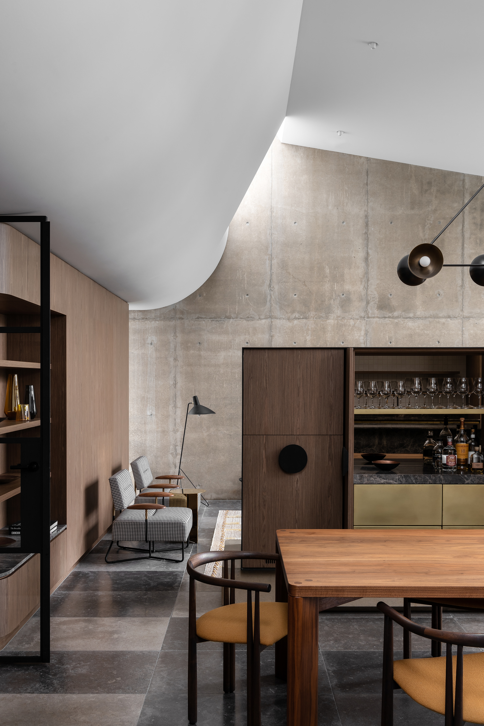 Open bar cabinet revealing glassware storage beneath the curved white ceiling plane