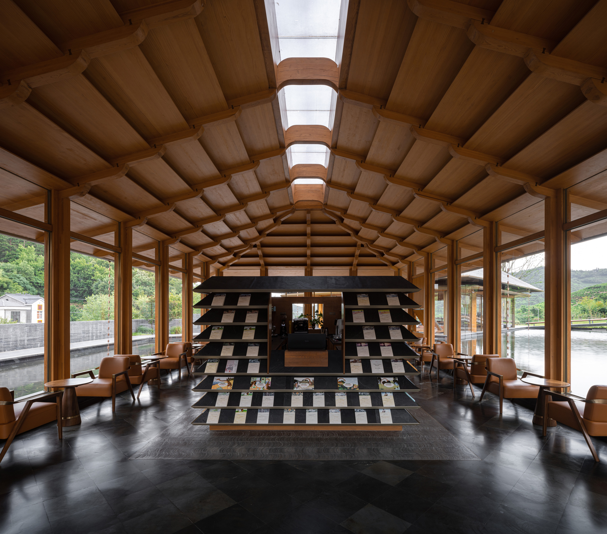 Interior hall with barrel-vaulted timber ceiling, skylights, and chequered black and white tile feature wall