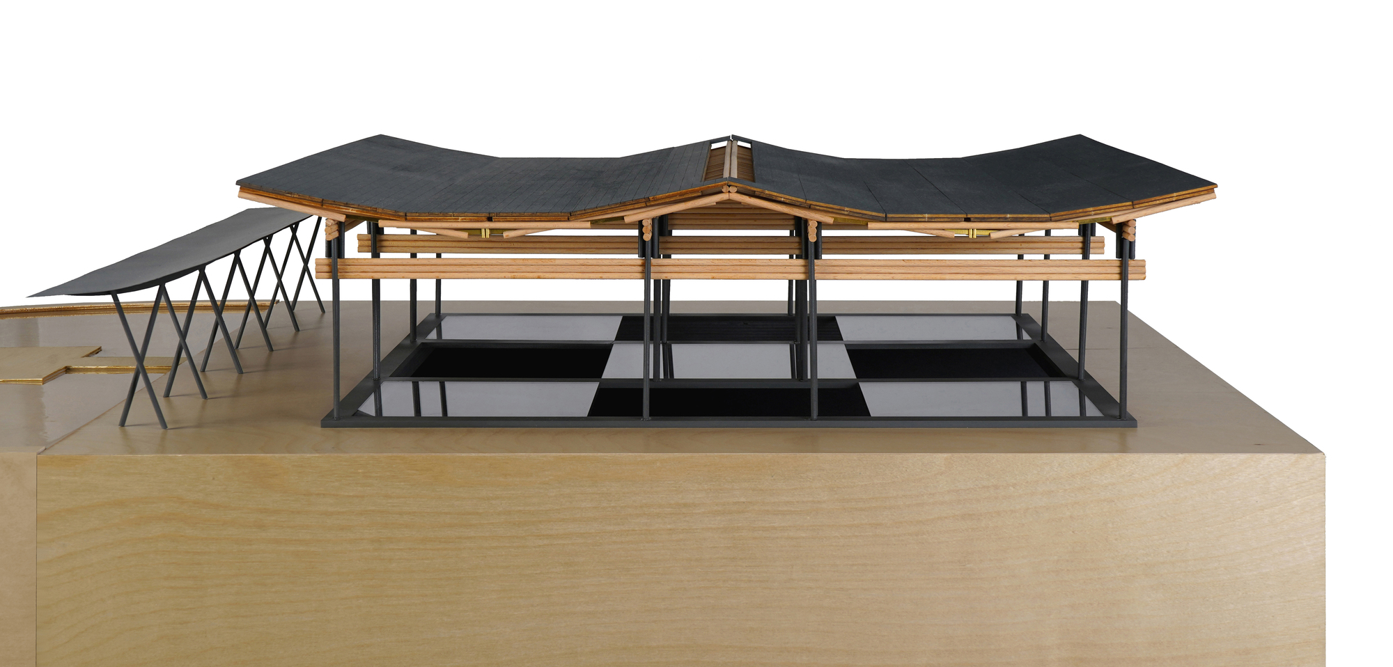 Physical model displaying the timber roof structure with dark cladding over a raised plinth base