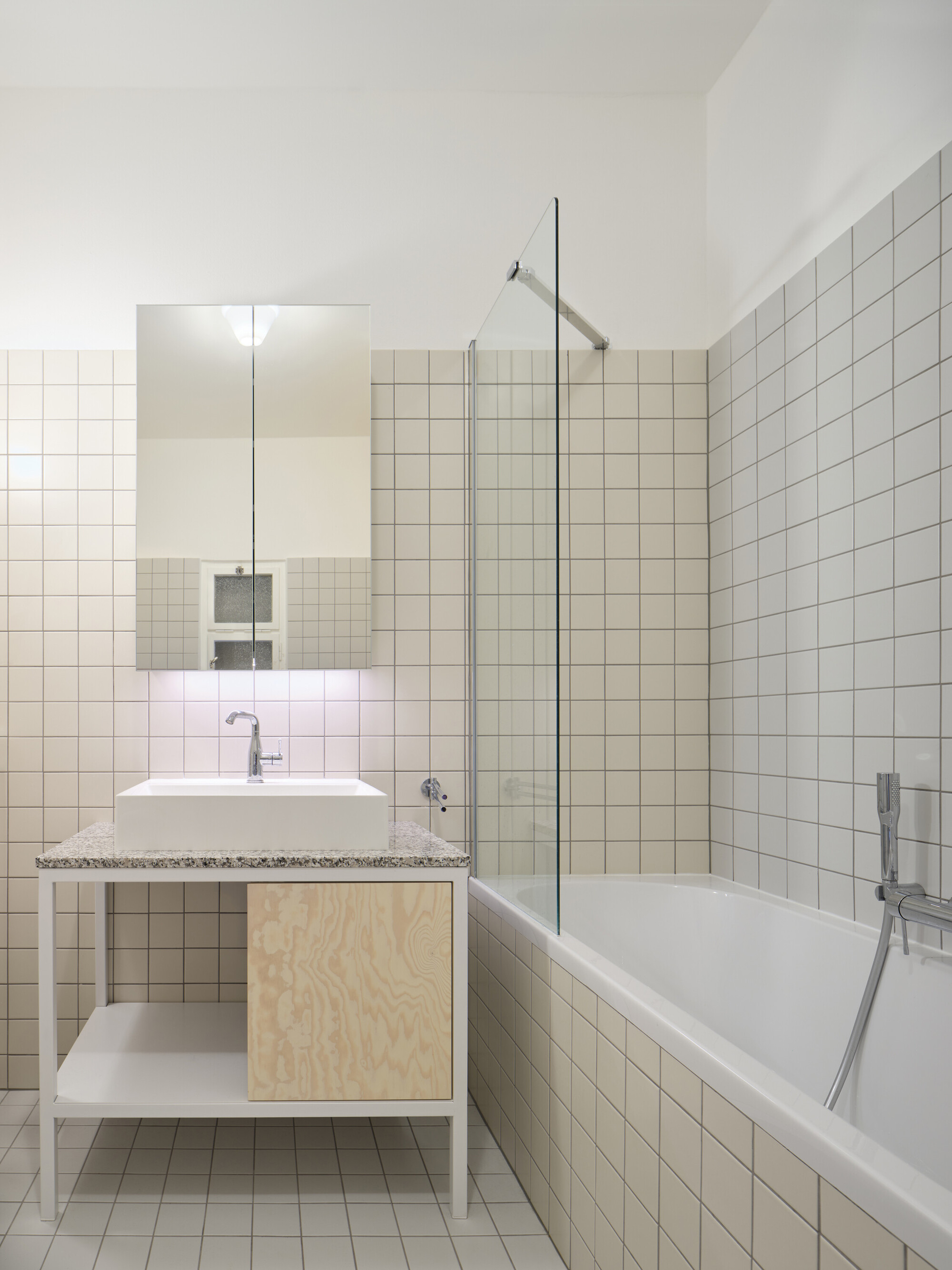 Bathroom with white square tile walls, floating vanity with plywood cabinet, and glass shower screen