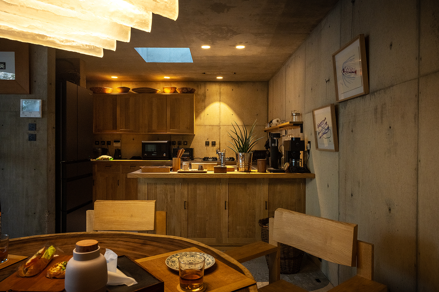 Kitchen with wood cabinetry and a stepped skylight in the concrete ceiling above