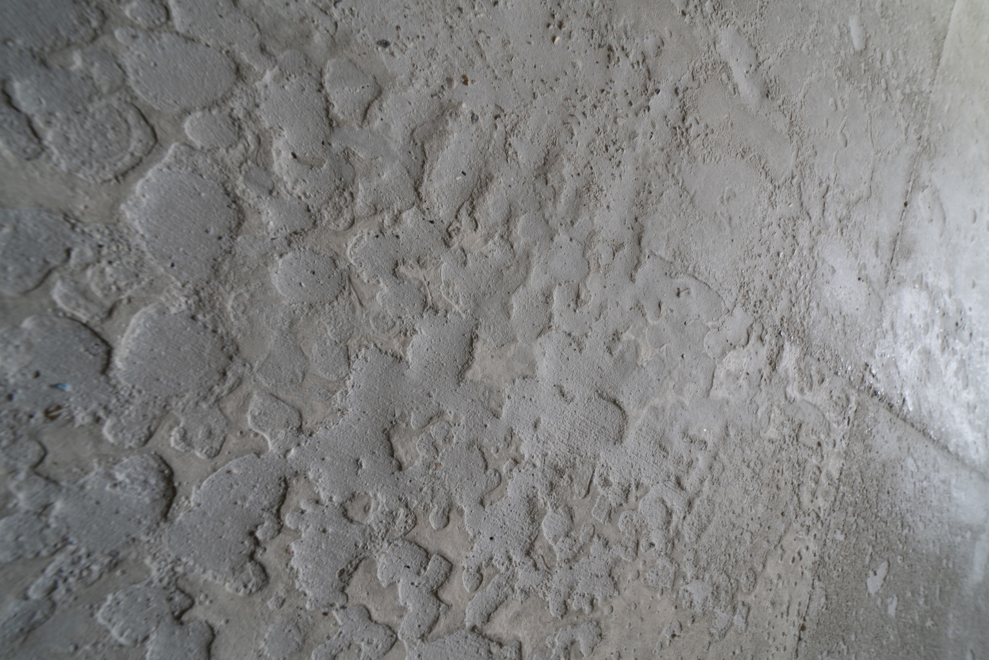 Close-up of board-formed concrete surface showing wood grain texture and tie-hole pattern
