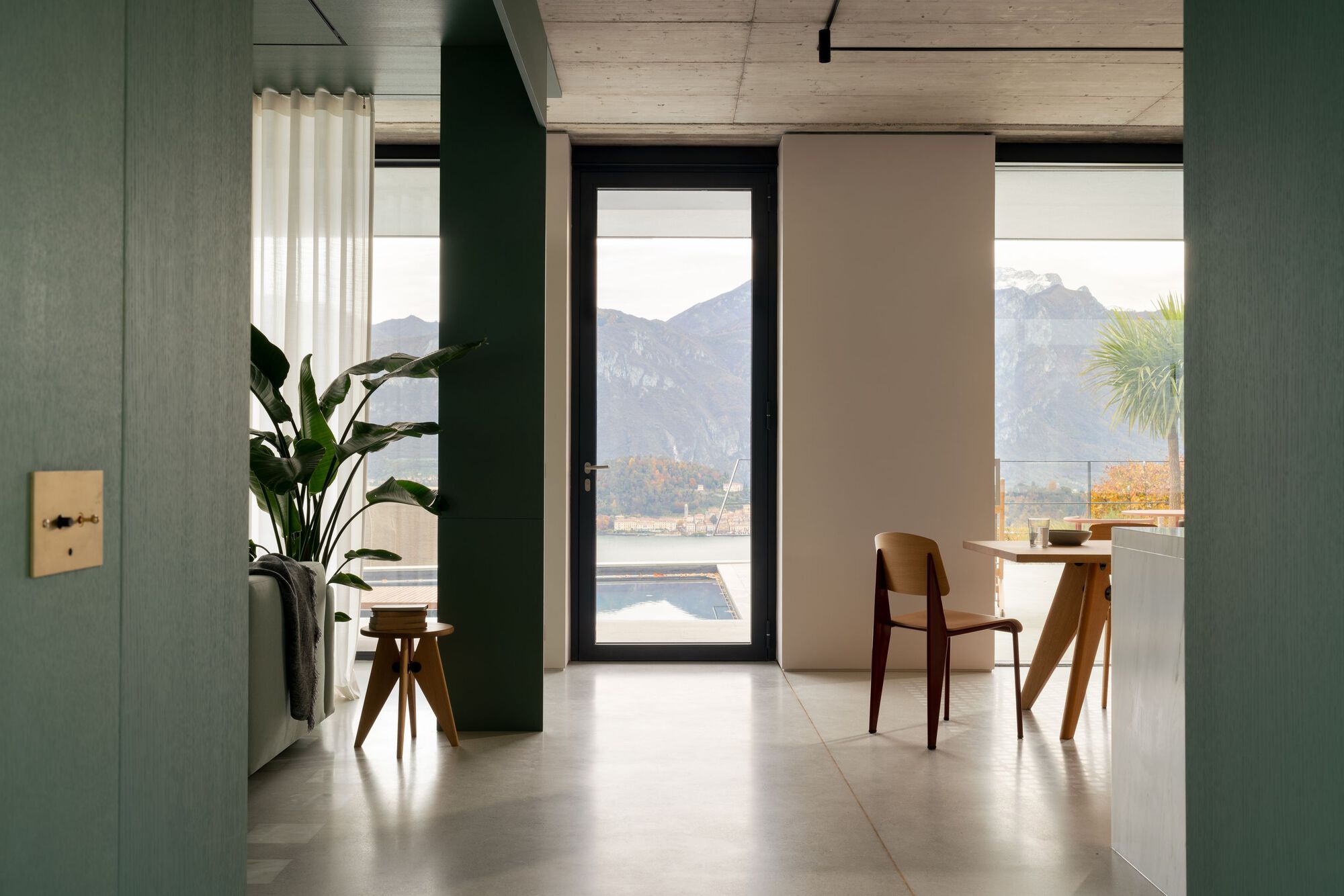 Interior room with curved partition wall framing mountain view through picture window