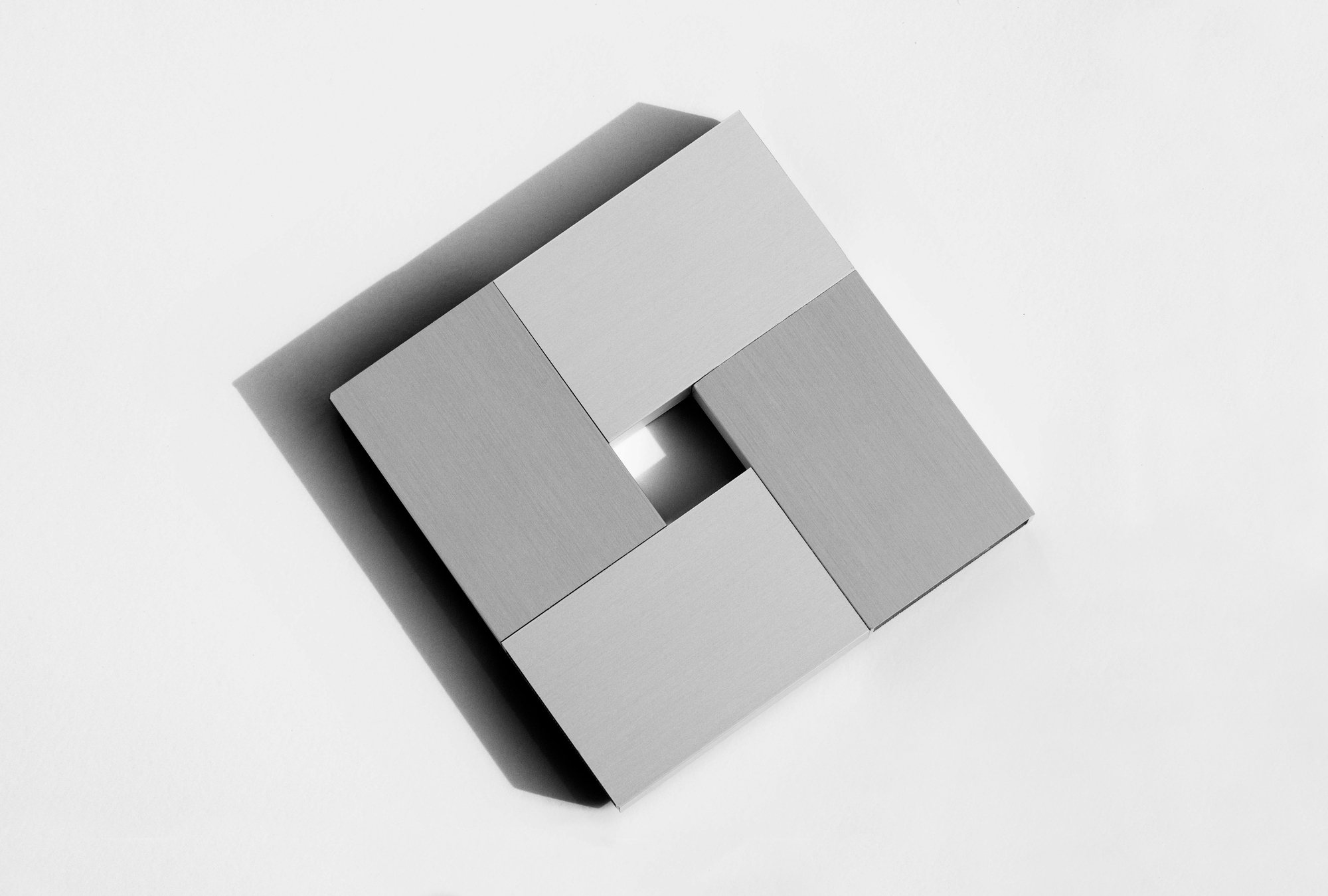Aerial view of architectural model showing four volumes arranged around a central courtyard void