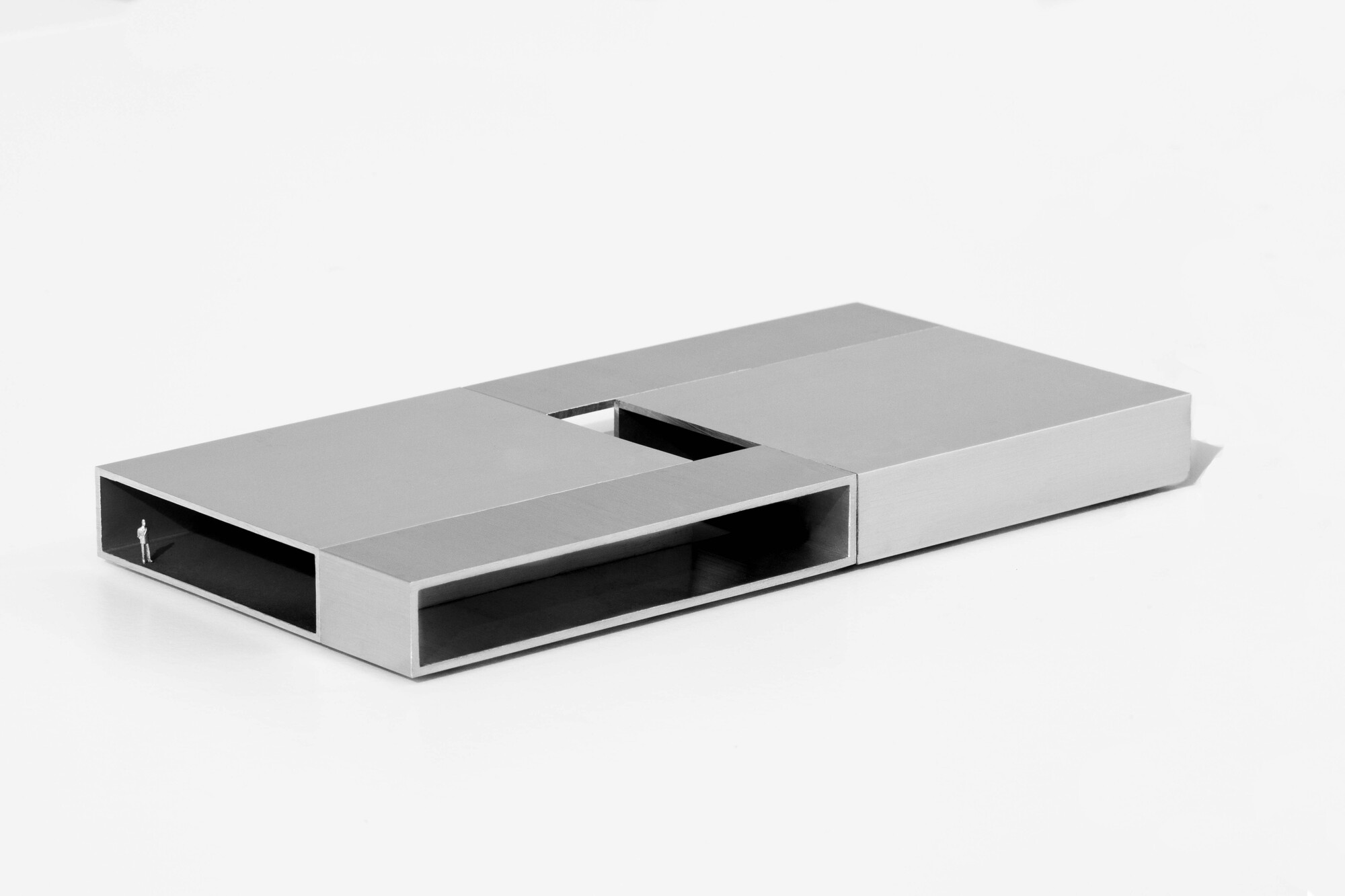 Angled view of model showing elongated window openings and recessed courtyard with figure