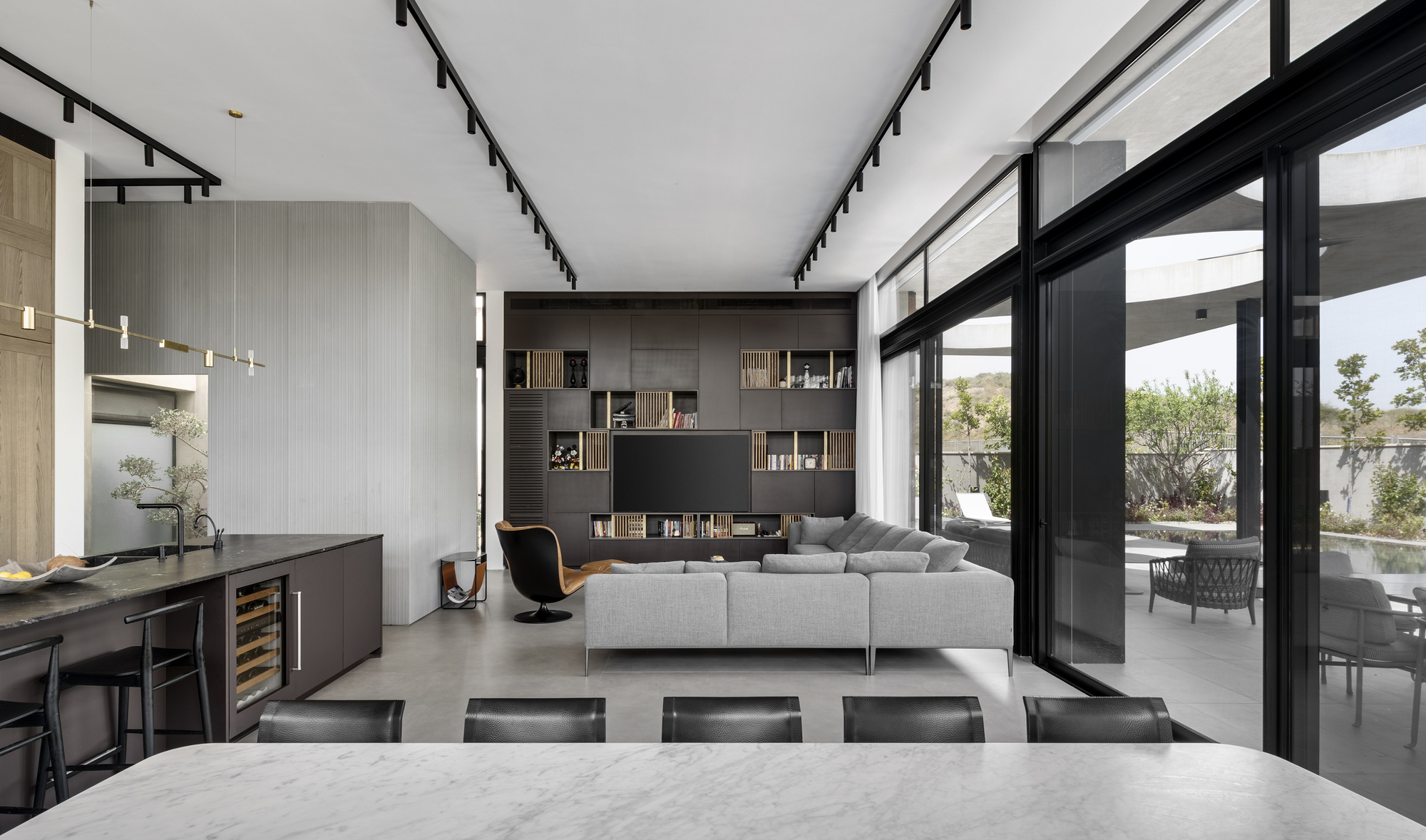 Open plan living space with built-in shelving and sliding glass doors opening to the garden
