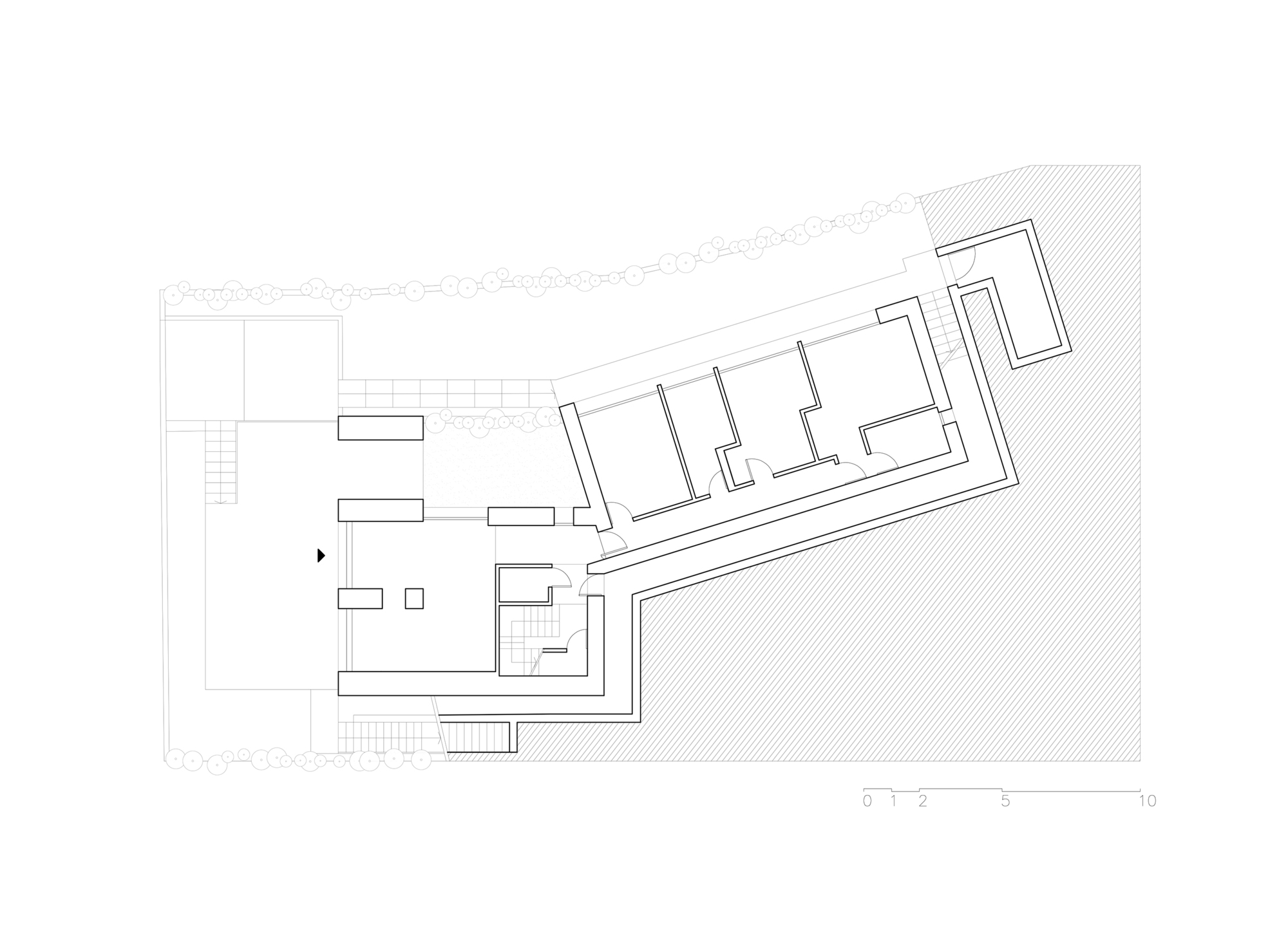 Ground floor plan drawing showing two connected rectangular volumes with interior rooms and landscaped border
