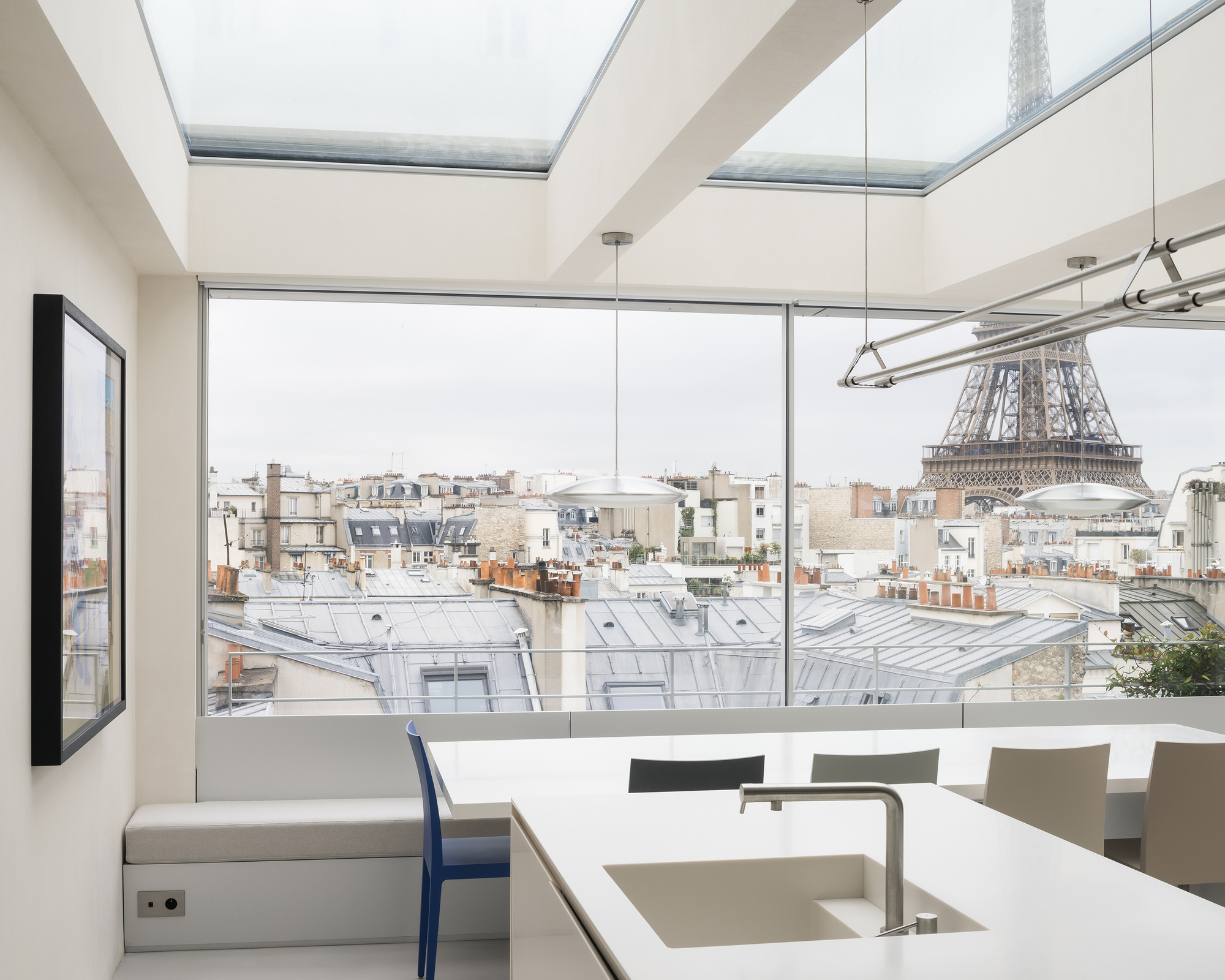 Kitchen with dual skylights and floor-to-ceiling window overlooking a rooftop cityscape