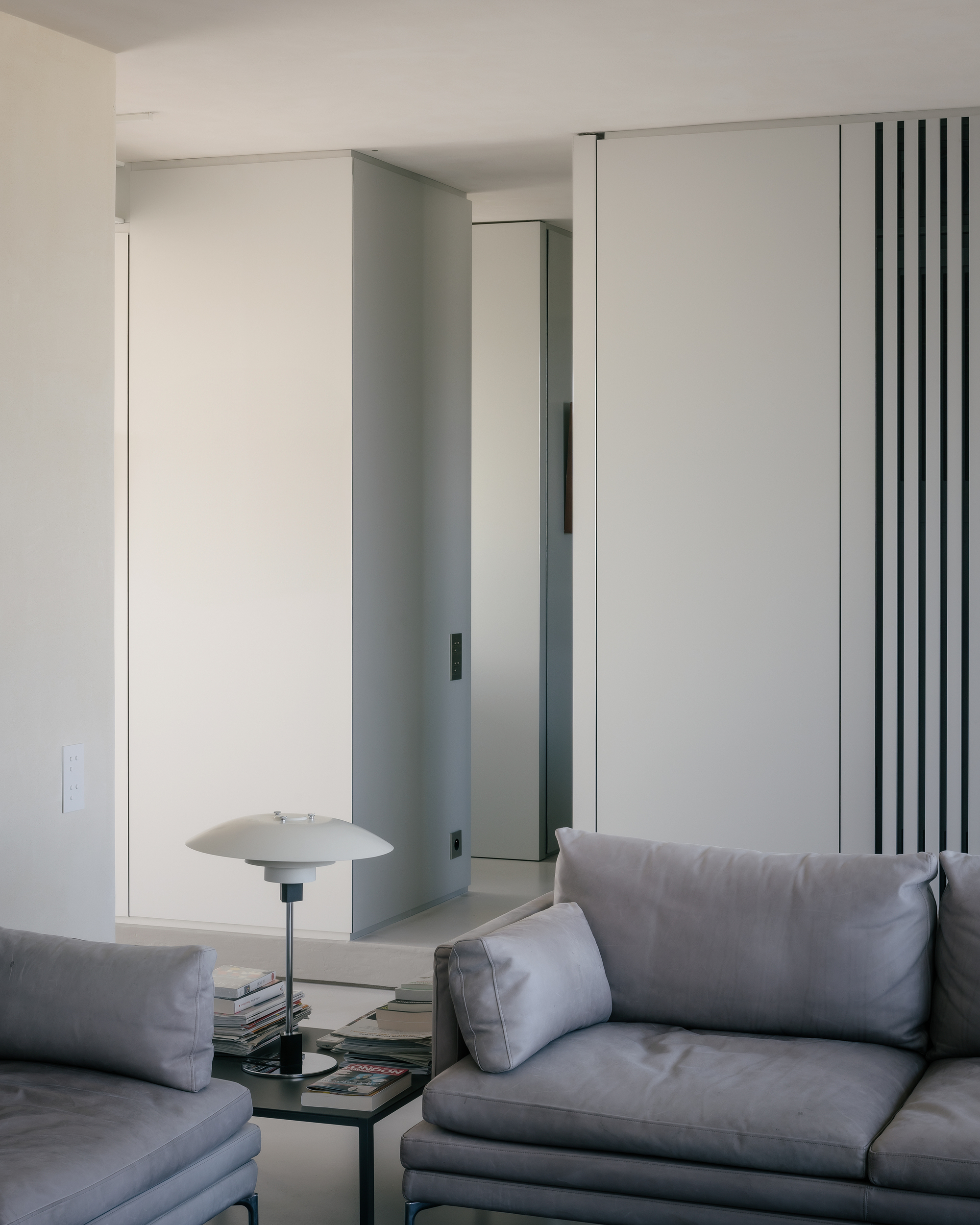 Living room with white partition walls featuring vertical black slat detailing