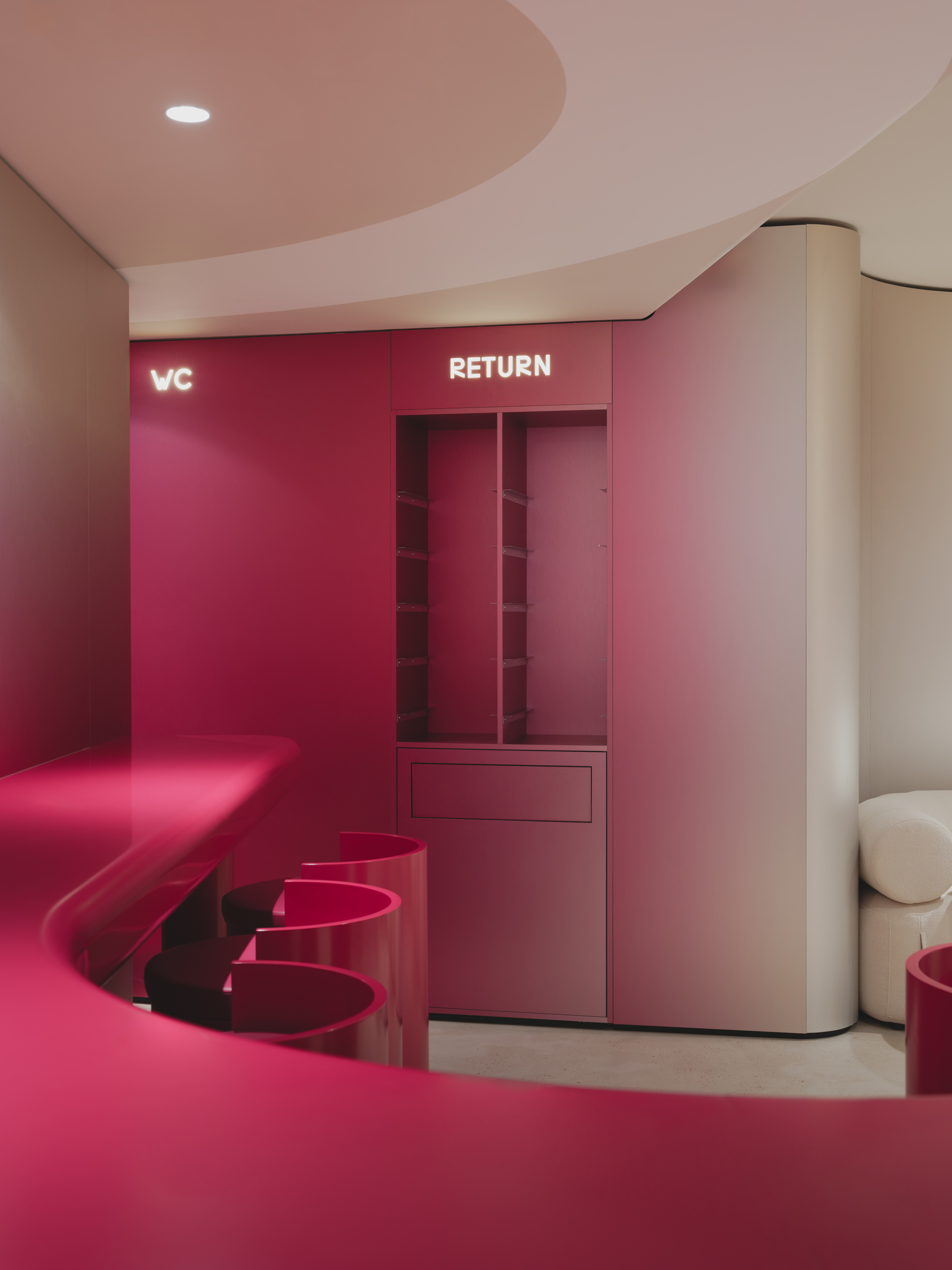 Return station with burgundy millwork, integrated storage cubbies and matching upholstered bench