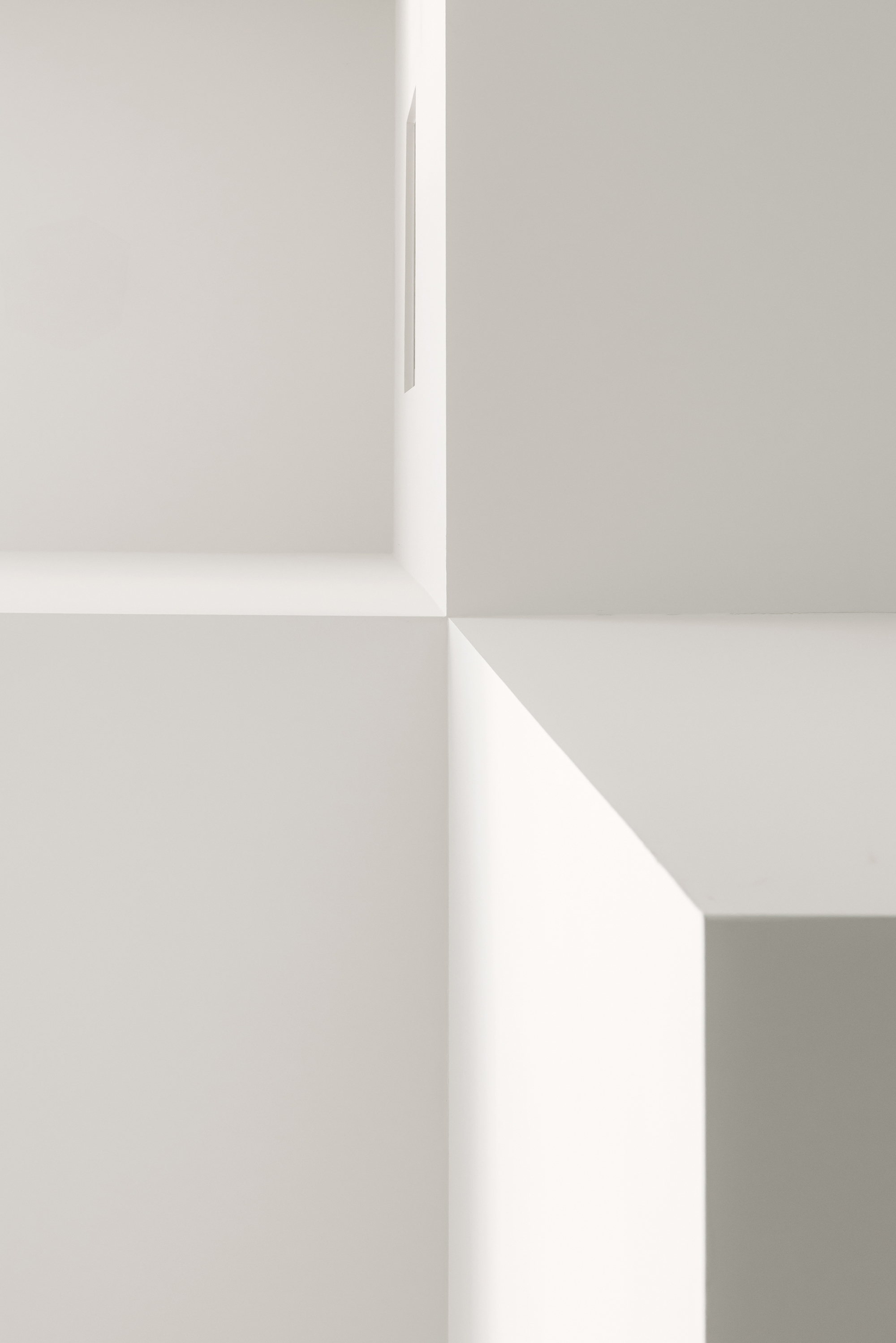 Close-up of white wall corners meeting at sharp angles under diffused natural light