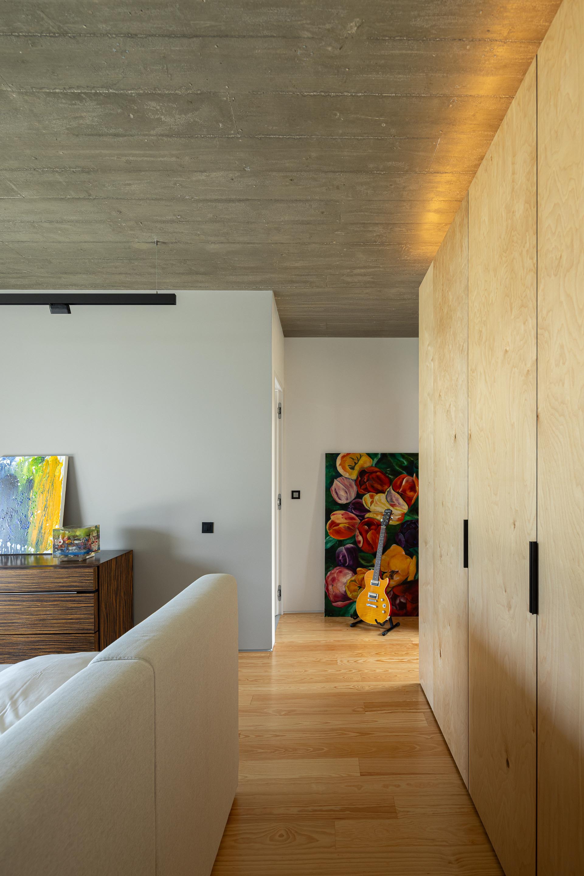 Hallway with plywood cabinetry and indirect ceiling lighting highlighting the timber boards above