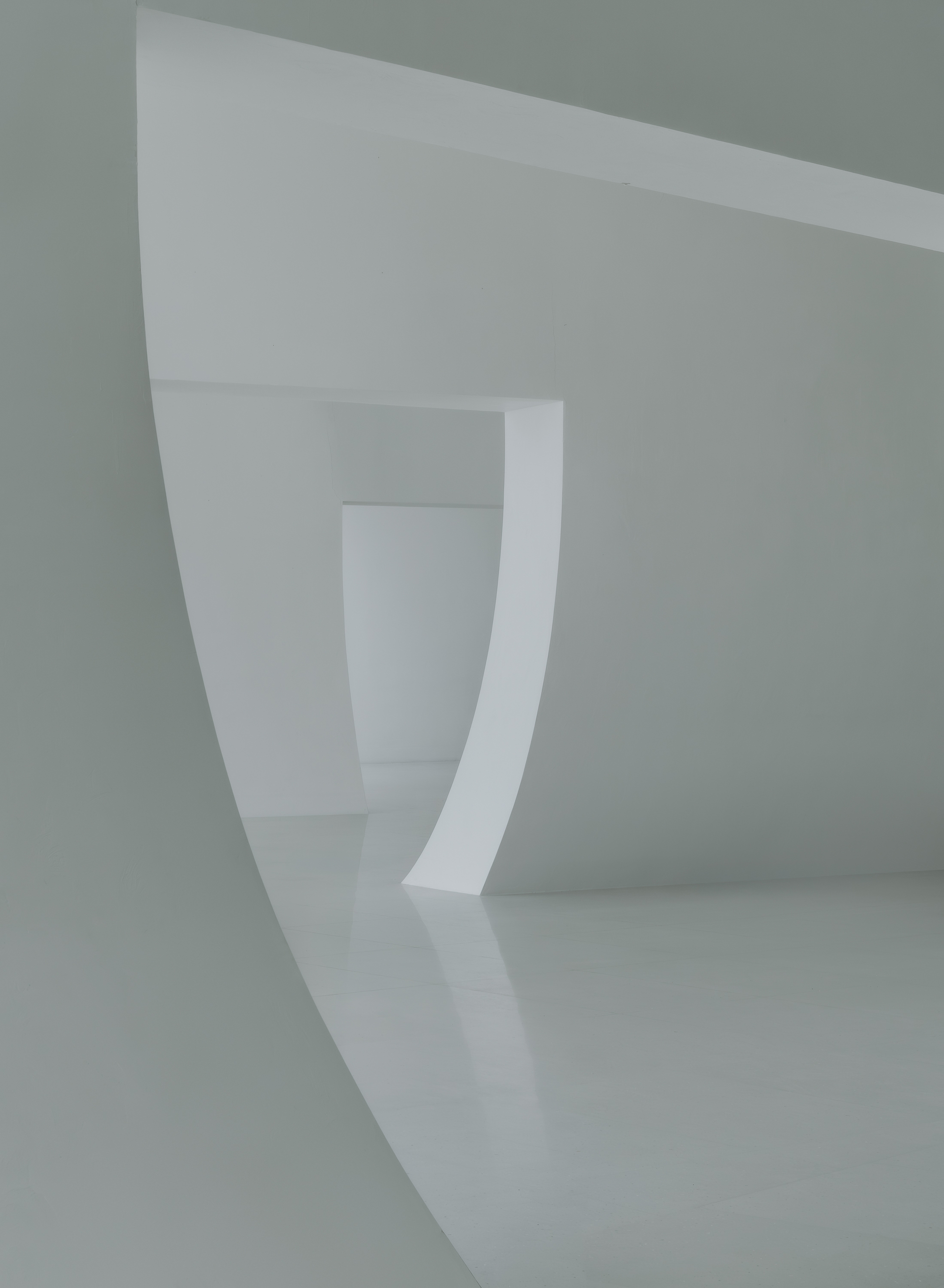 Series of curved white thresholds receding through connected interior spaces under diffused light