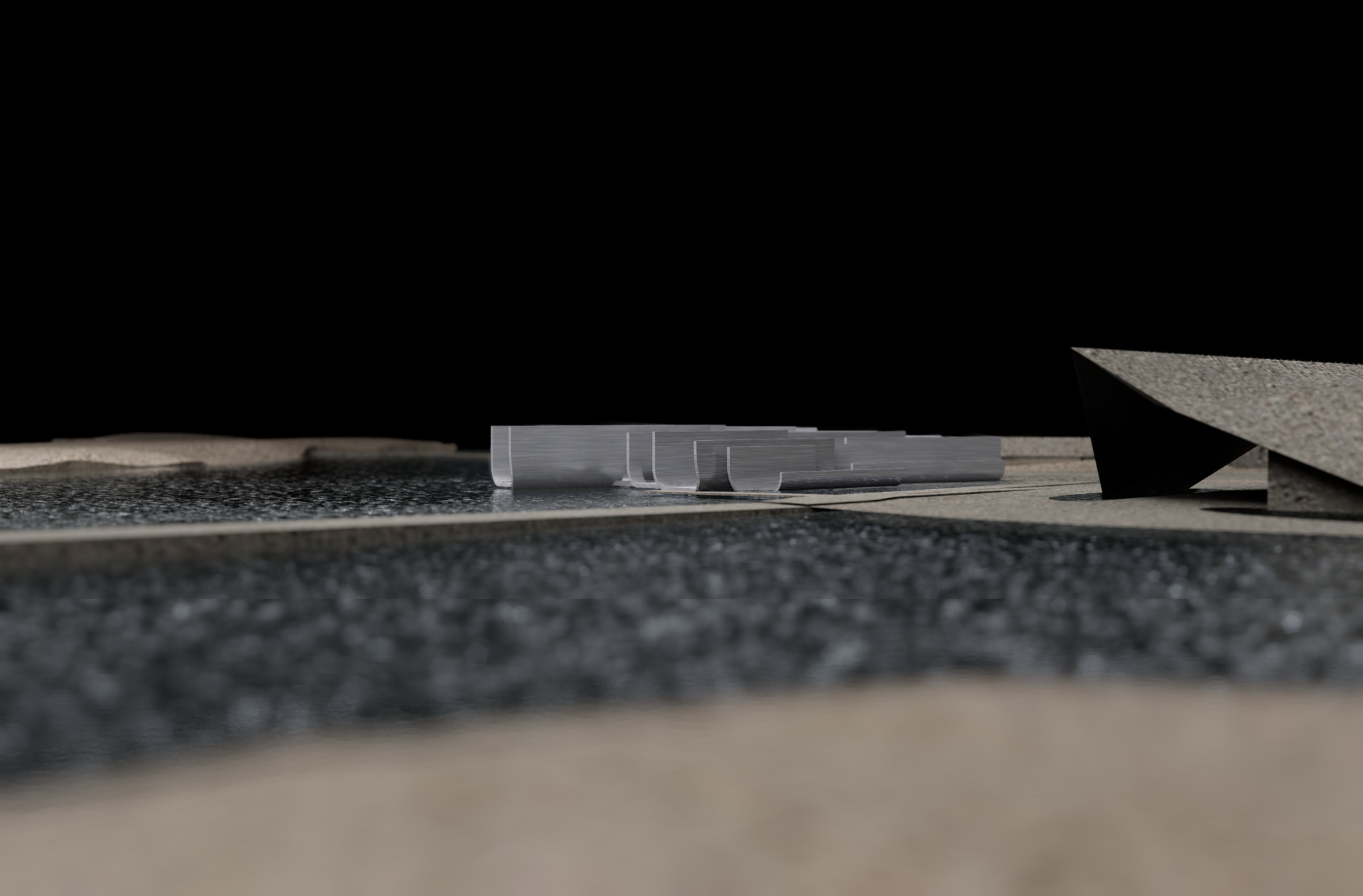 Eye-level view of a physical model showing a low horizontal volume between textured landscape planes