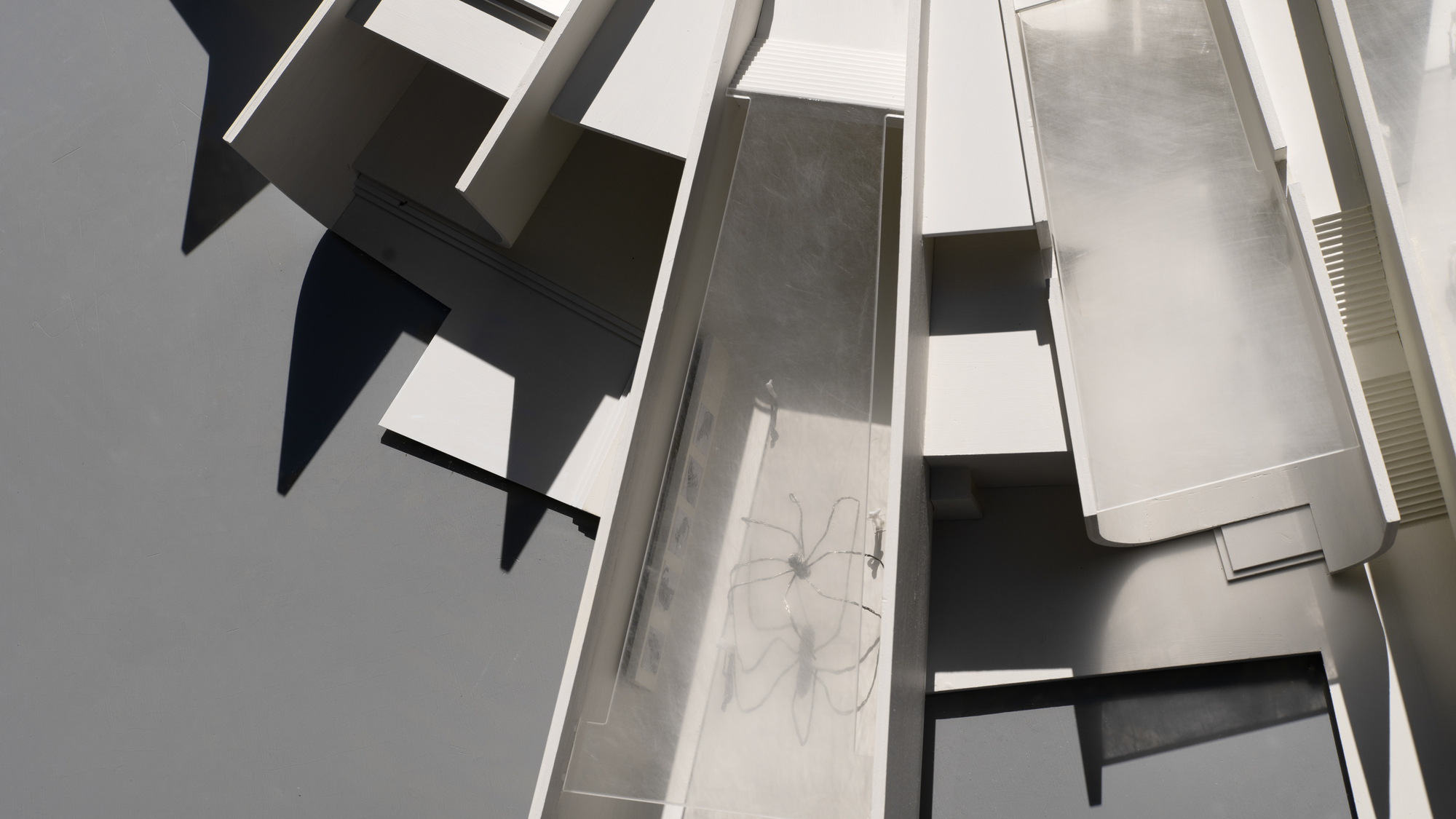 Overhead view of physical model revealing courtyard with curved interior walls and roof openings