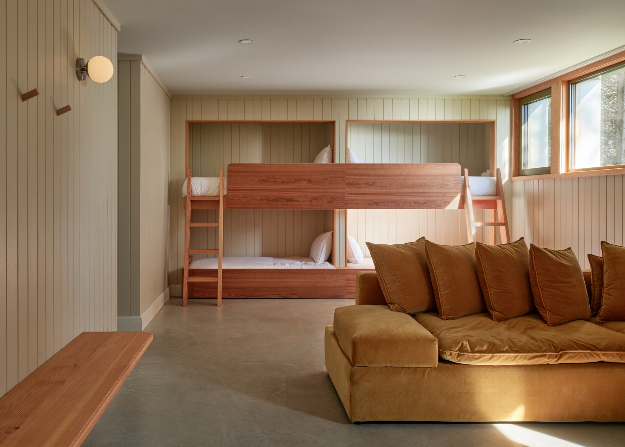 Bunkroom with built-in timber beds recessed into tongue-and-groove wall niches