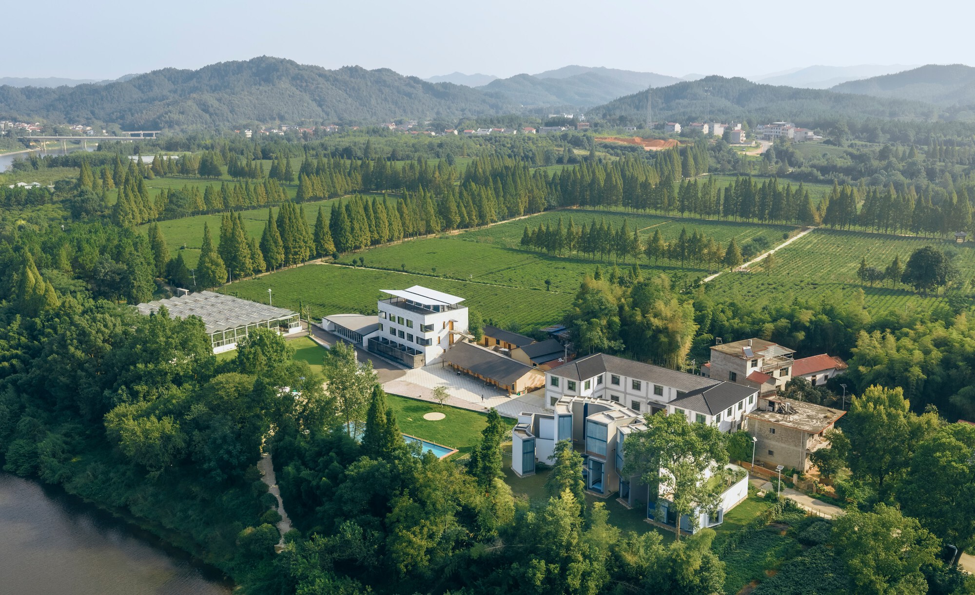 Aerial view of the compound surrounded by farmland, tree rows, and rolling hills