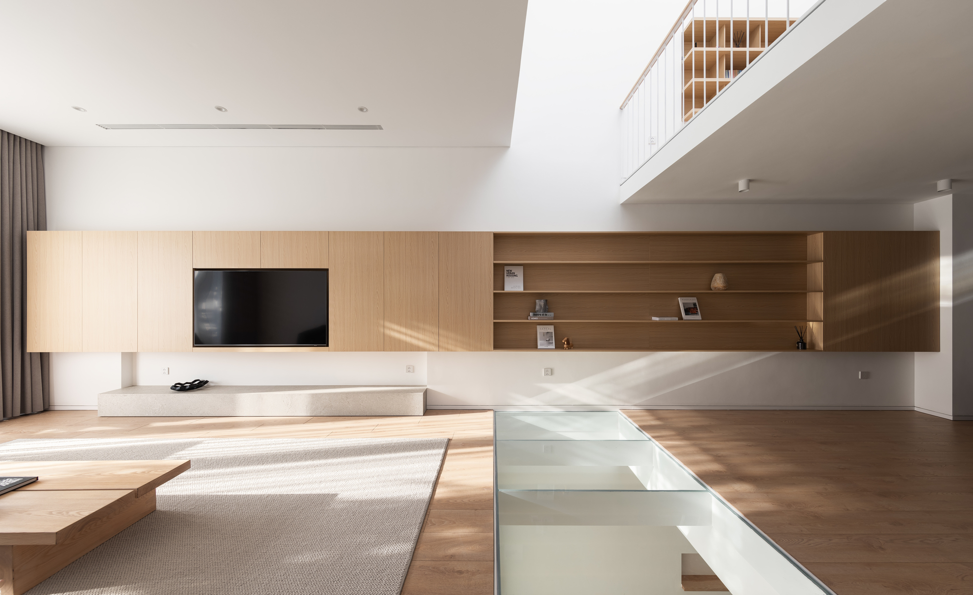 Living room with timber wall unit and sunlight streaming across the wood floor