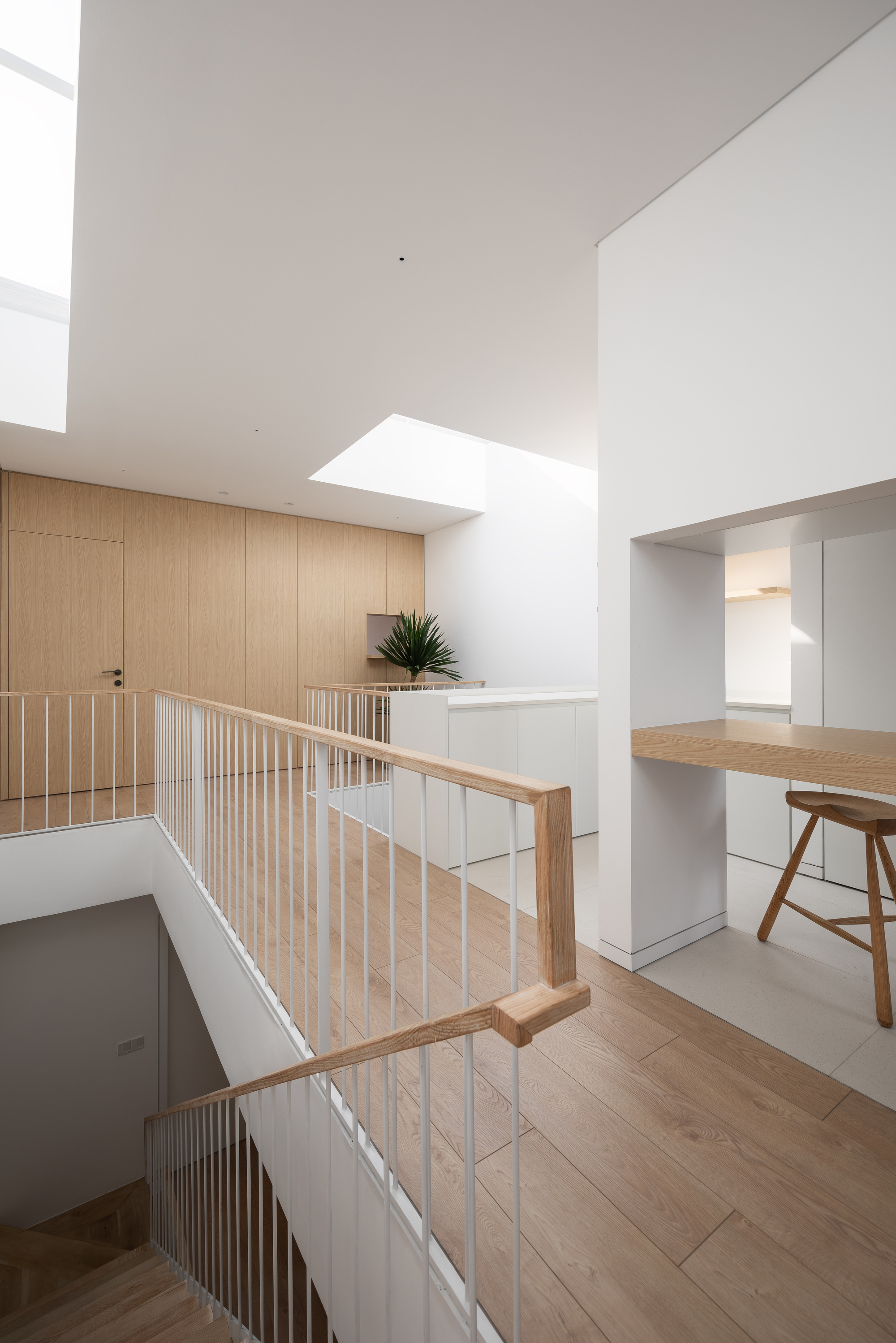 Upper landing with timber balustrade and skylight above a planted ledge