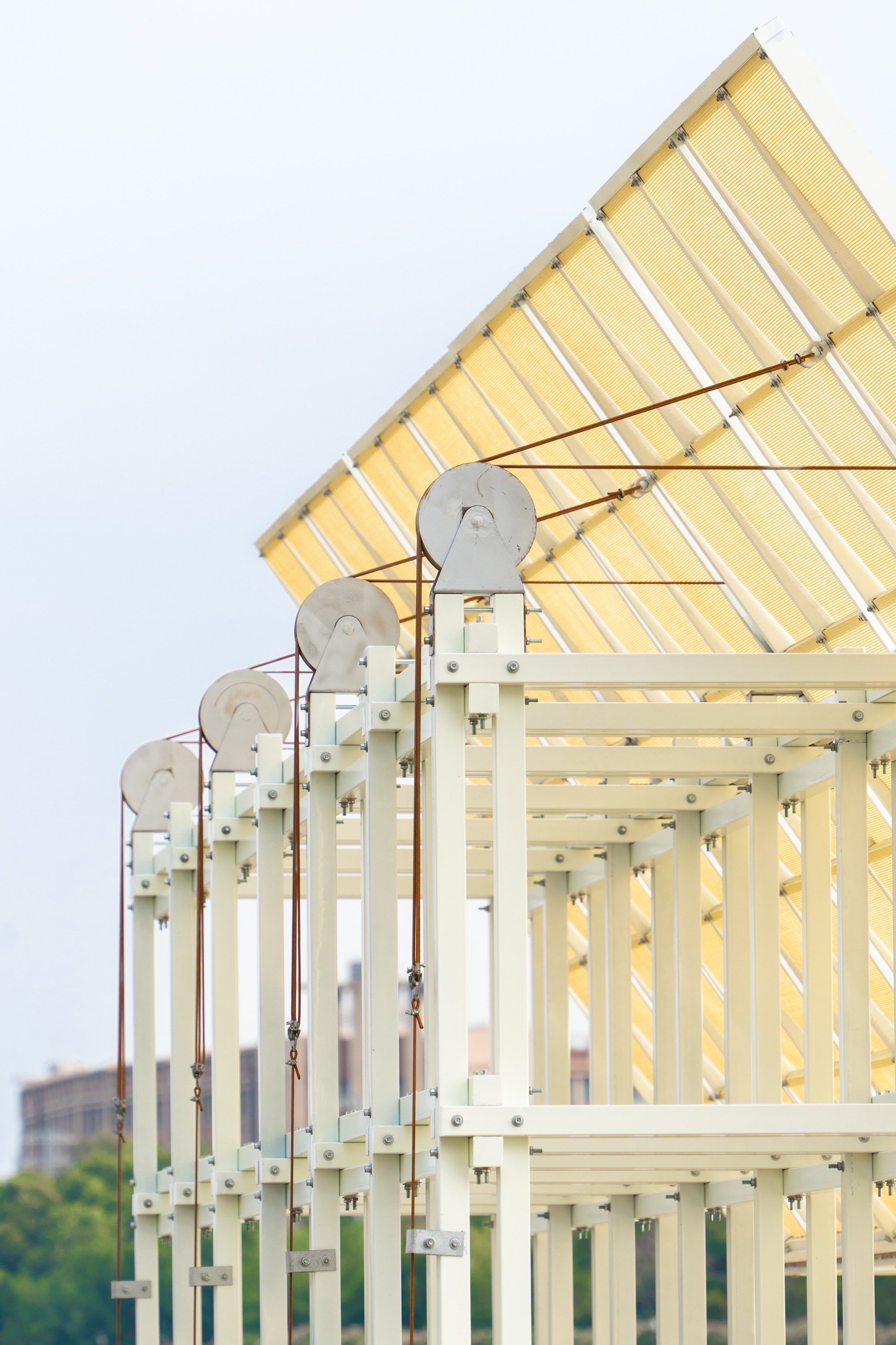 Detail of the gabled roof corner showing pulley mechanisms and white steel frame members