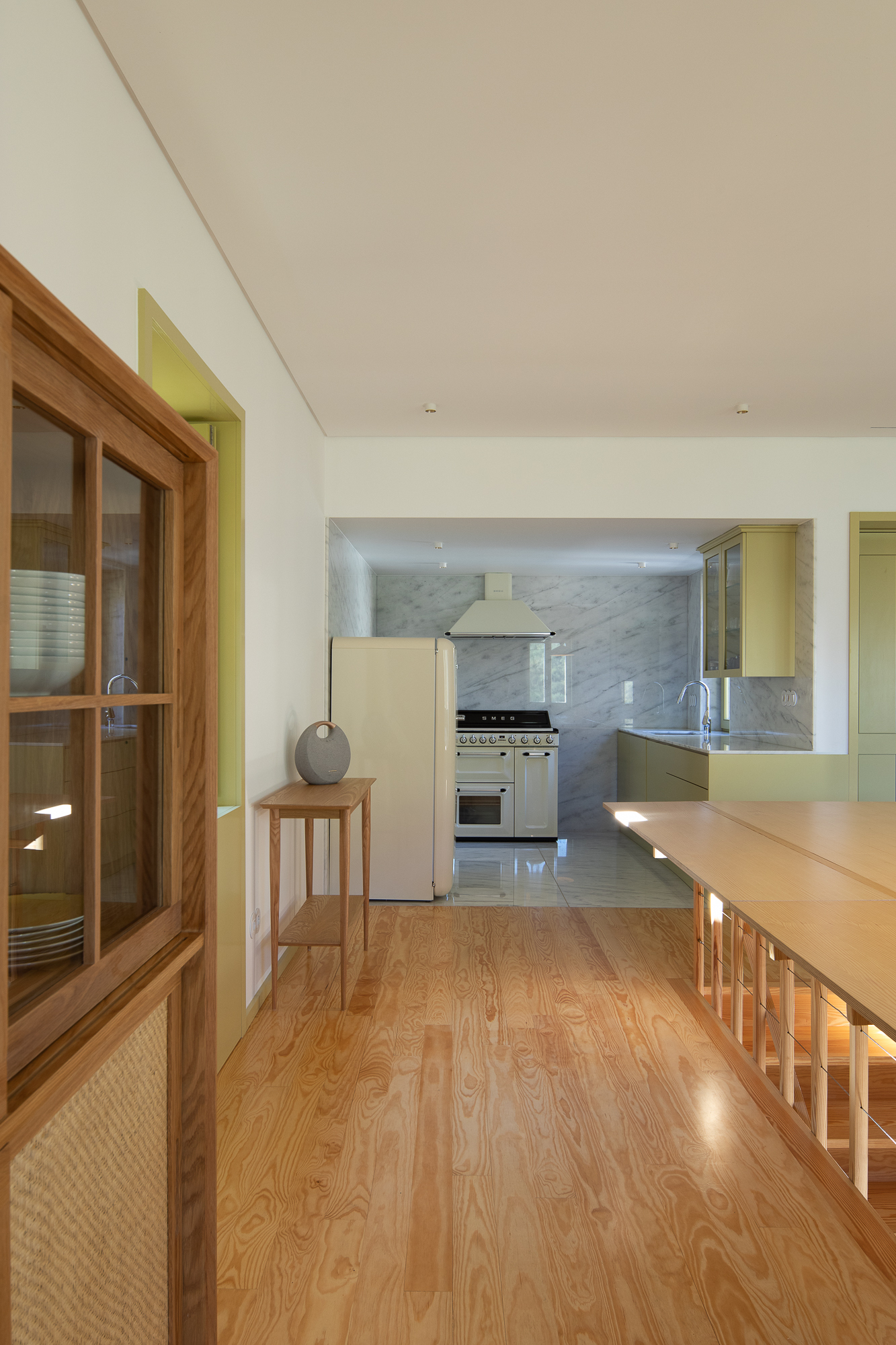 Open-plan kitchen and dining area with timber cabinetry and flooring under white ceiling with skylight