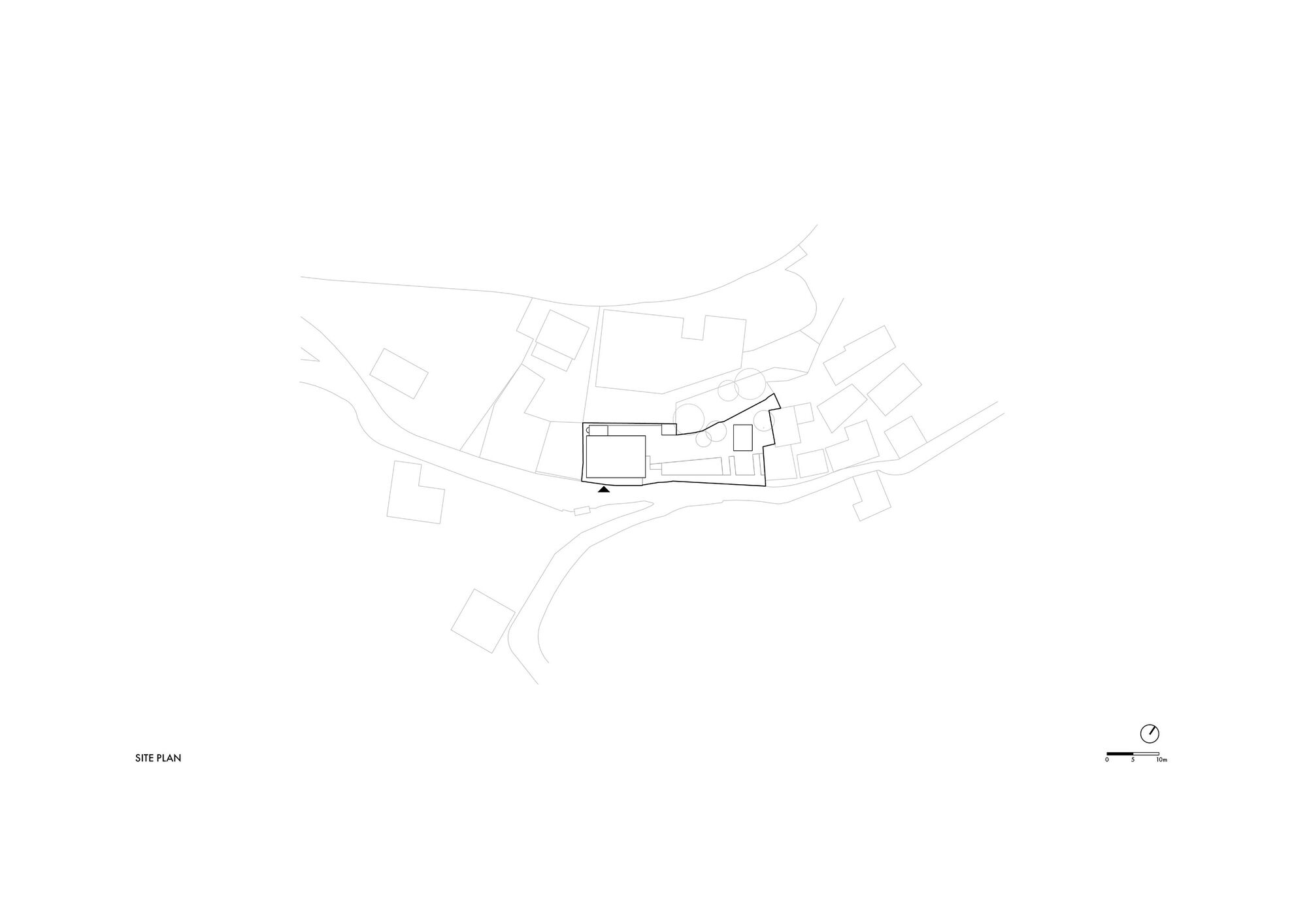 Site plan drawing showing building footprint among adjacent structures and curving site roads