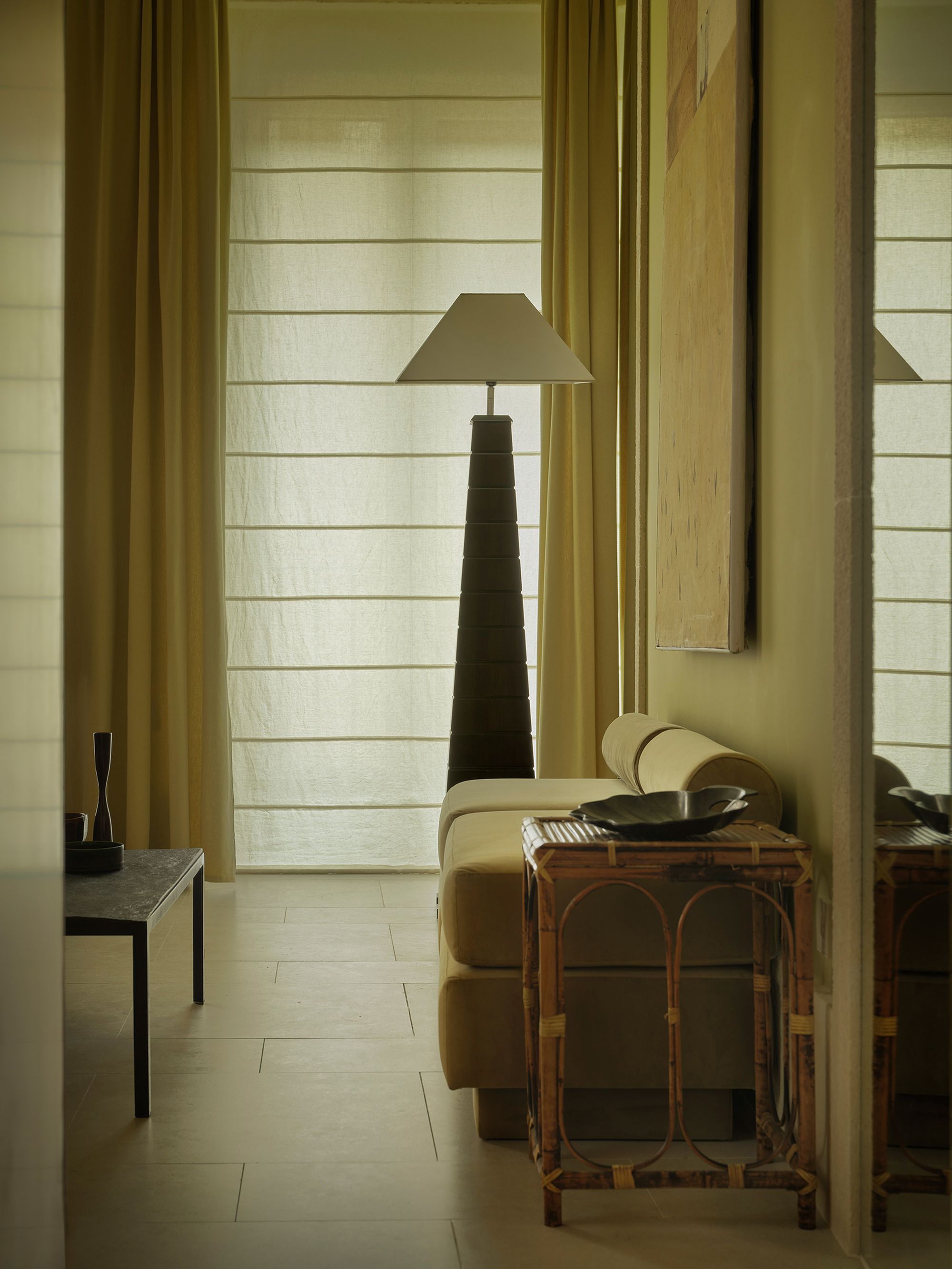Reading nook with horizontal white timber cladding, yellow curtains, and a tapered pyramidal lamp