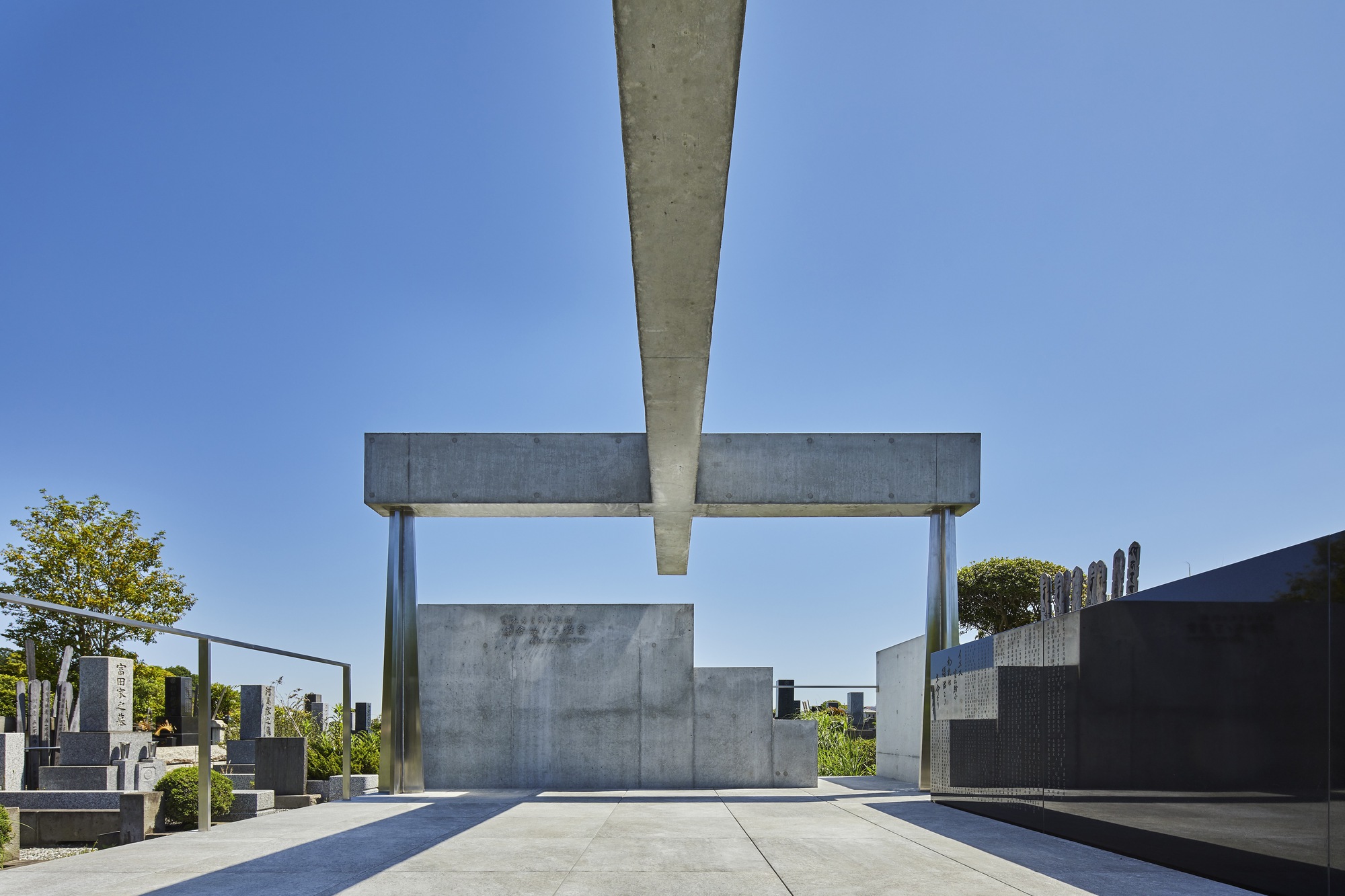Underside view of cantilevered concrete beam meeting steel column above enclosed monument chamber