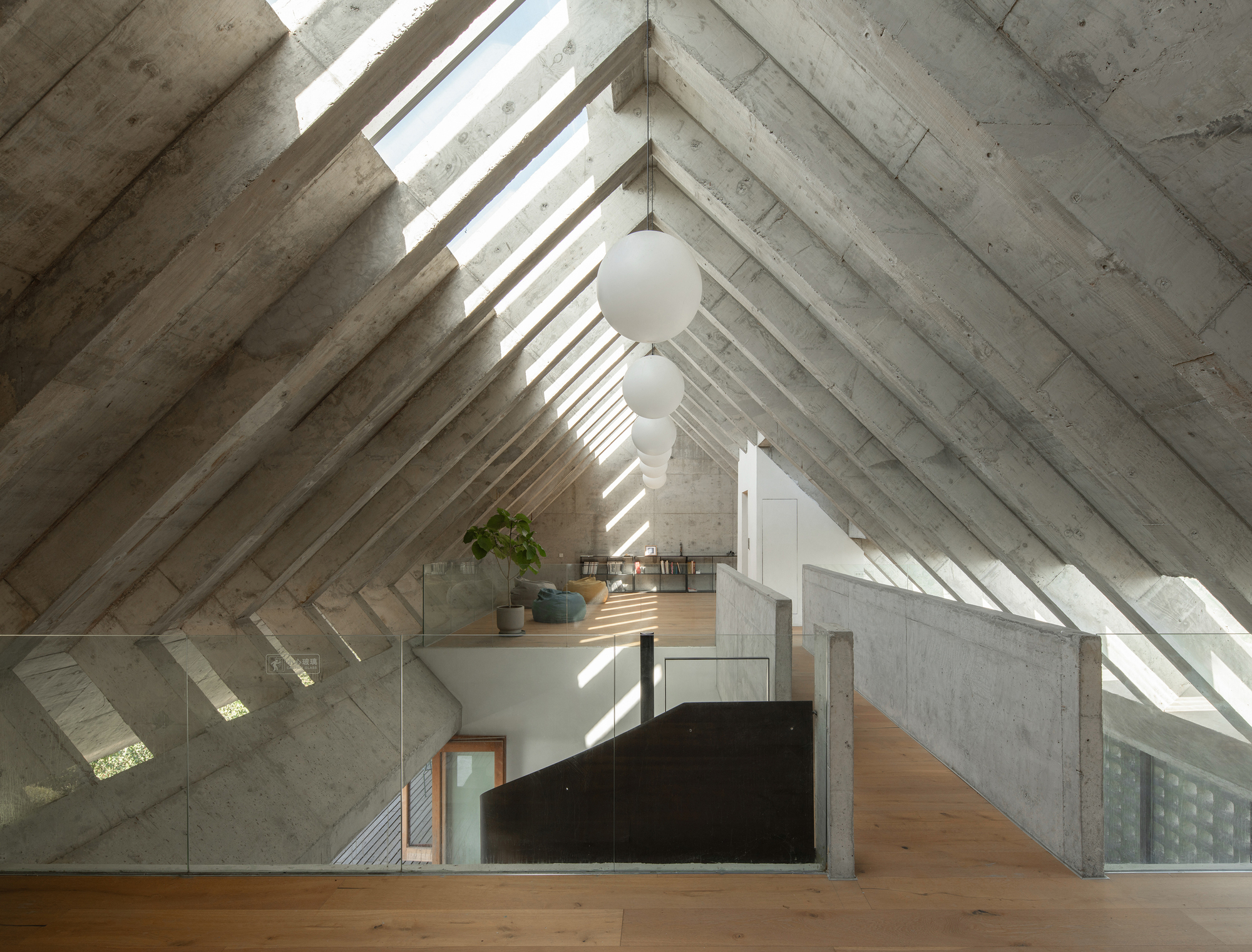 Vaulted concrete ceiling with rhythmic beams and skylights above a lofted timber floor with suspended globe pendants