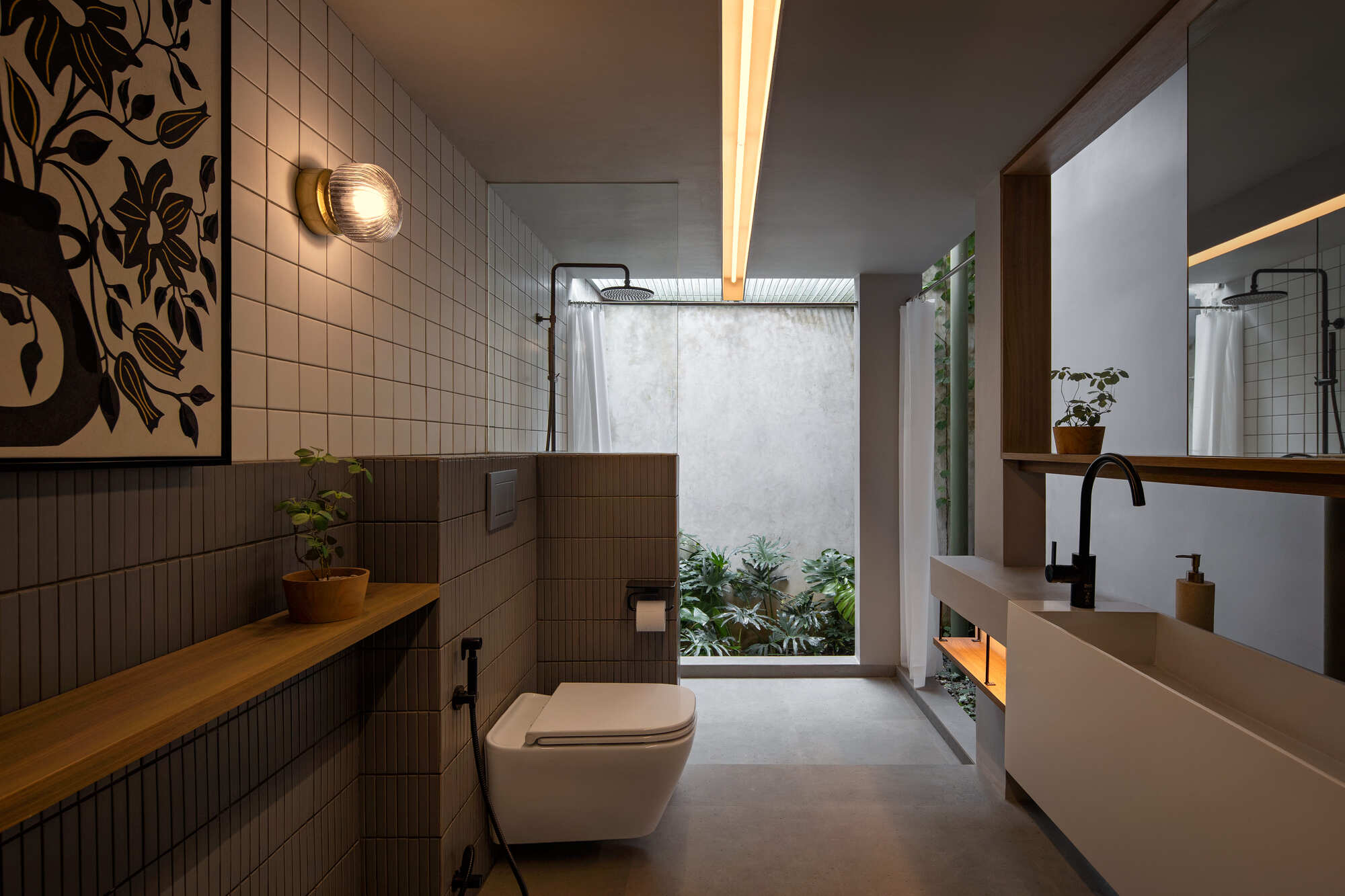 Bathroom with square tile walls and timber ledge opening to a small planted lightwell