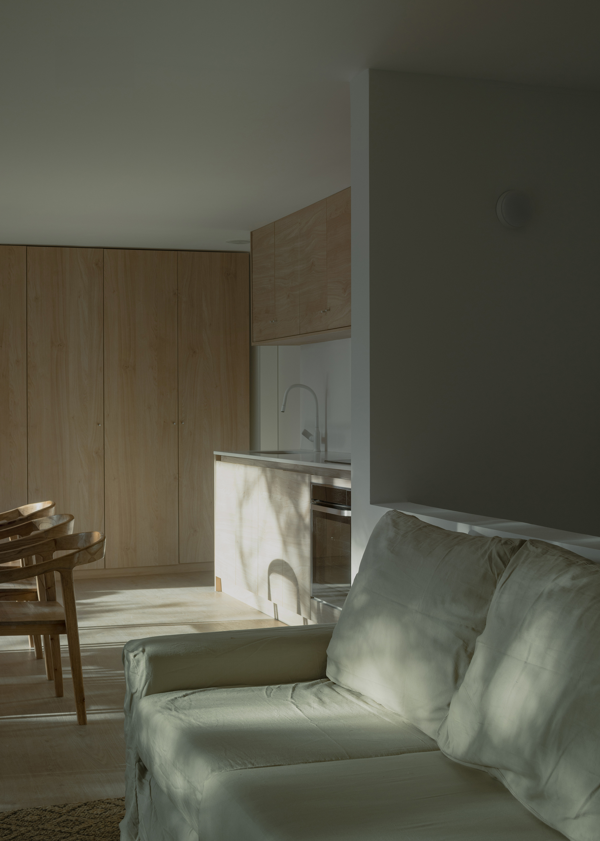 Open plan interior with timber cabinetry and marbled island bathed in morning sunlight