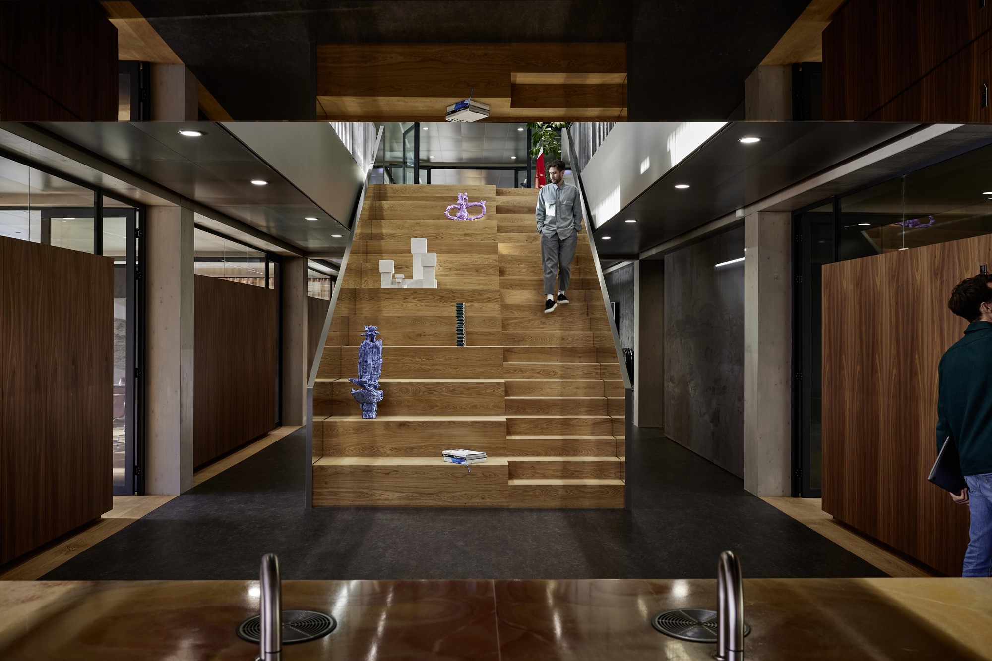 Interior staircase in timber connecting levels with a child seated on the steps