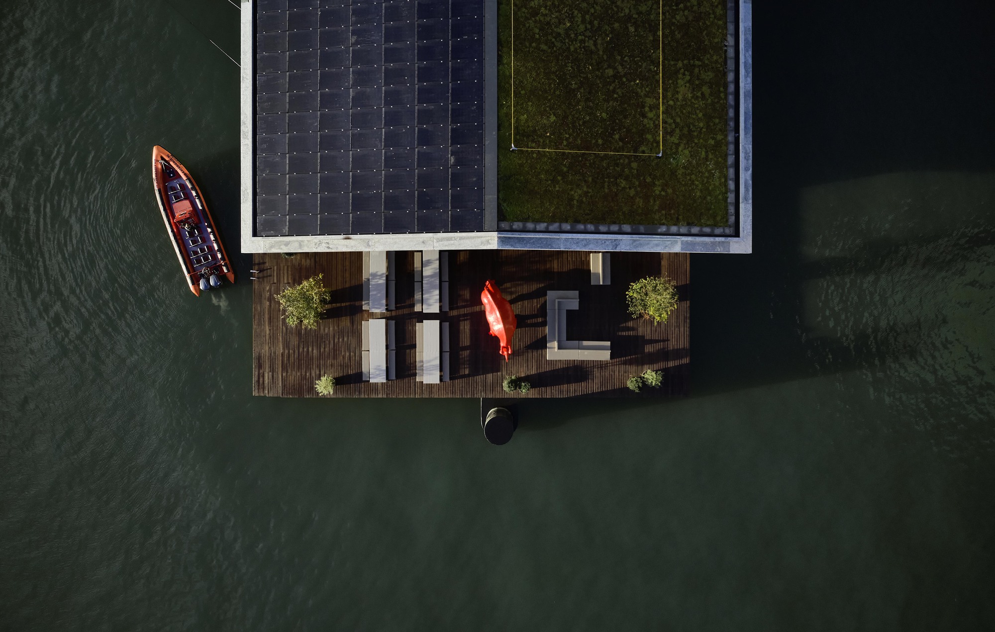 Drone view of the solar panel roof and timber deck with kayaks moored alongside