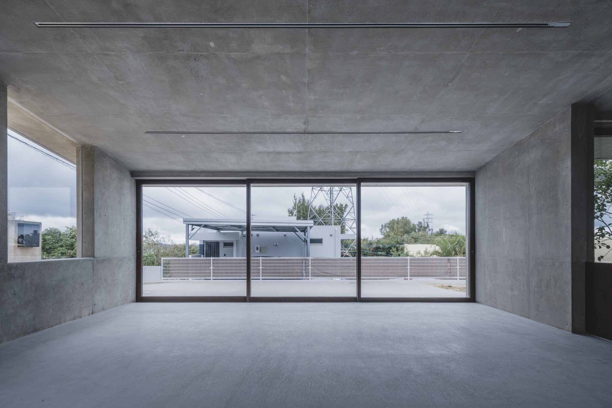 Upper level interior with panoramic sliding glass doors overlooking rooftop terrace and neighboring buildings