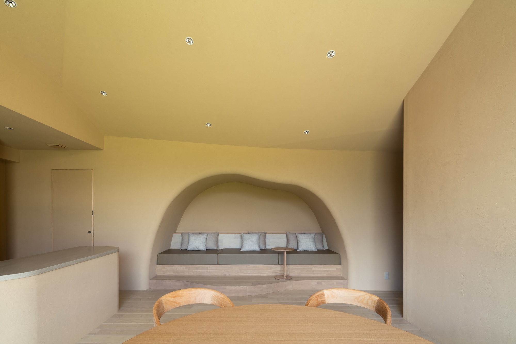 Interior view of dining area with built-in bench beneath a plastered arched alcove