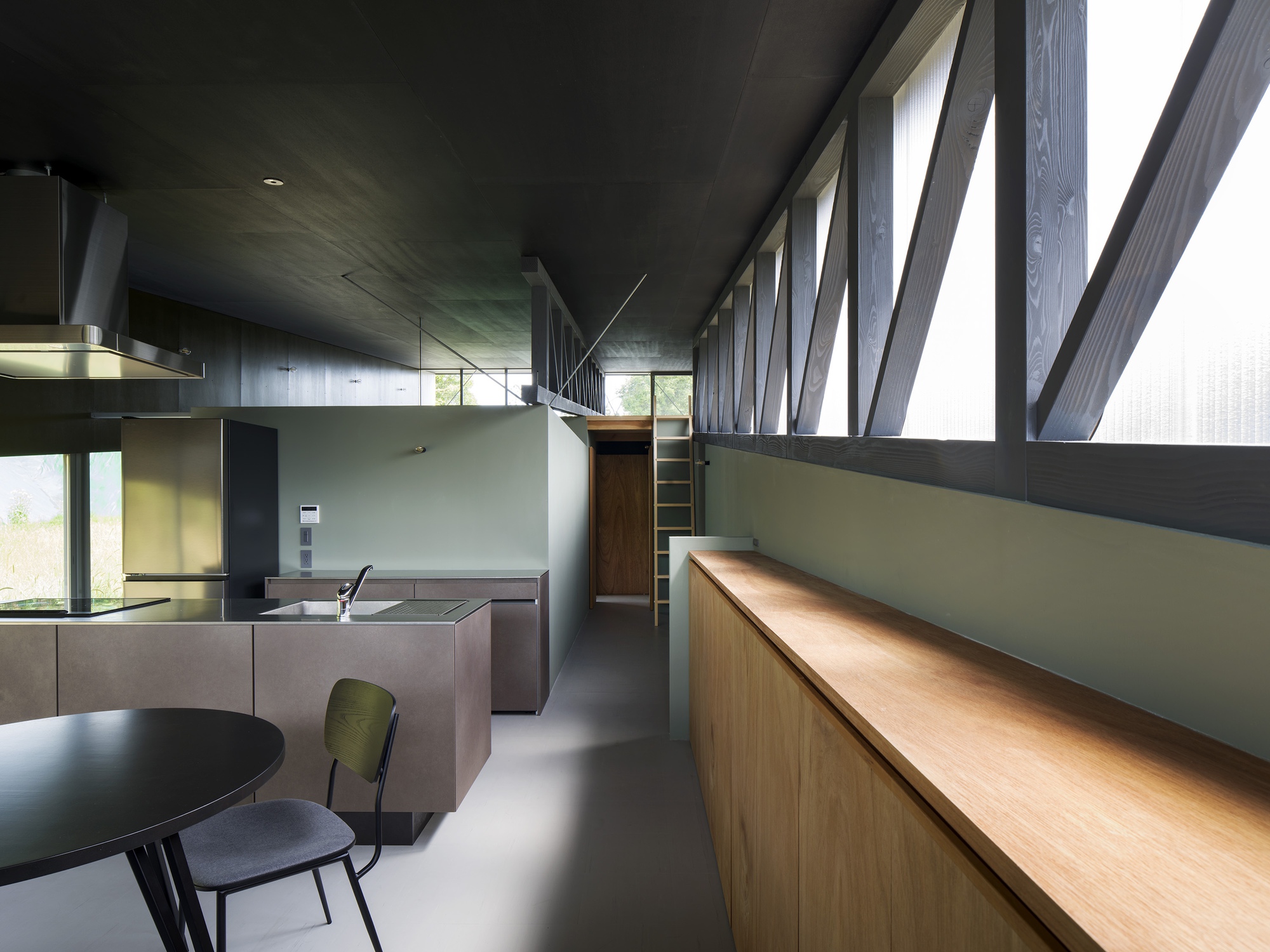 Open kitchen and dining area with diagonal timber bracing visible through translucent upper windows