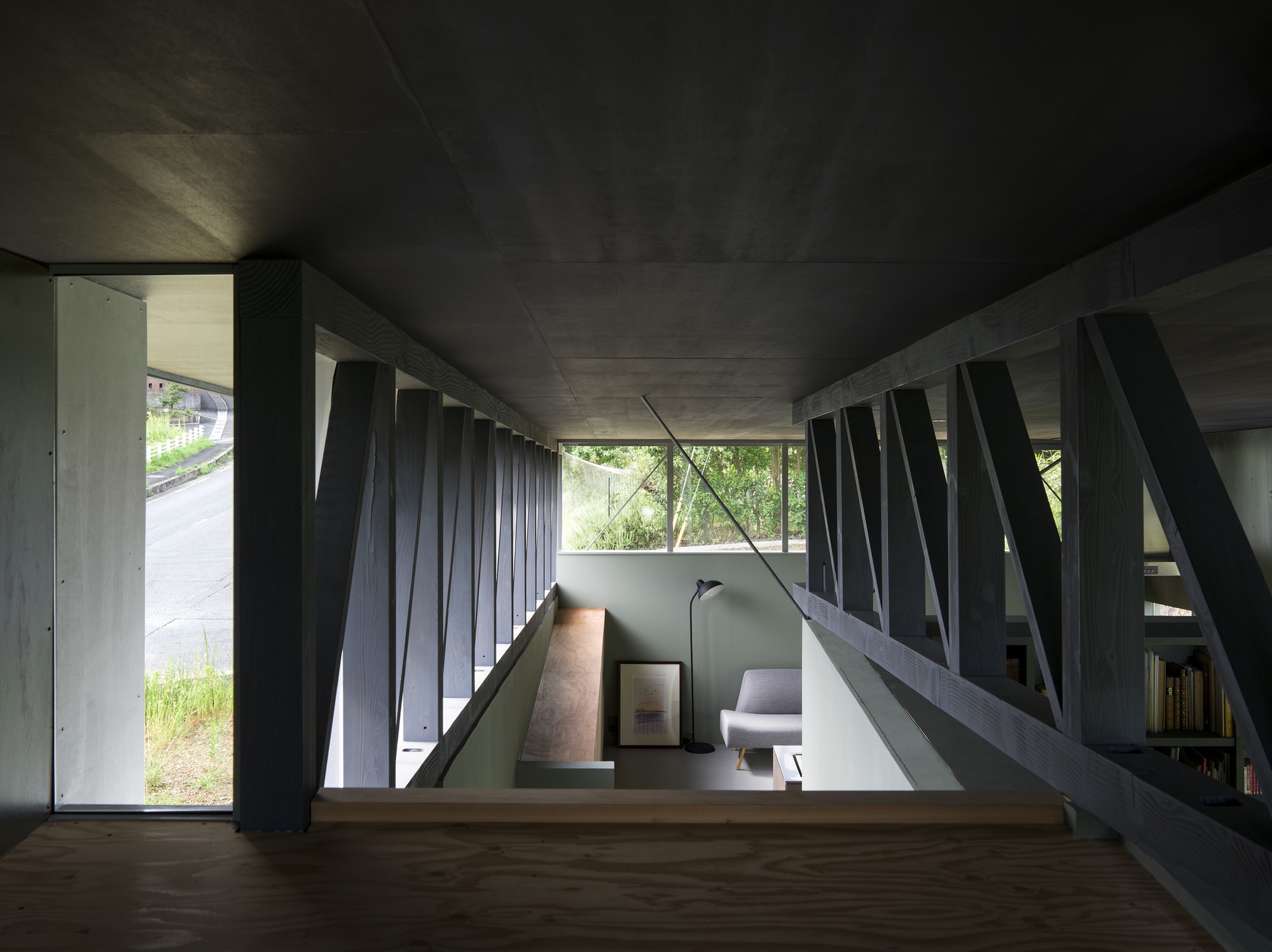 Double-height interior with diagonal steel bracing pattern along clerestory windows and timber floor below